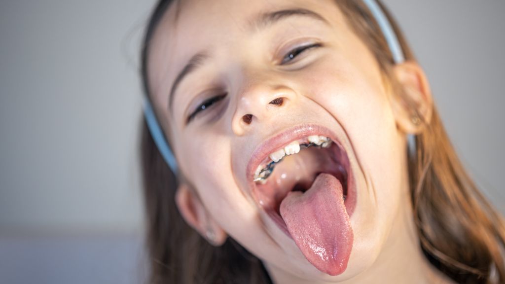  Menor haciendo una mueca con la cara sacando la lengua
