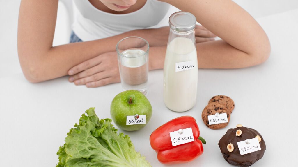  Mujer mirando unos alimentos etiquetados con sus calorías