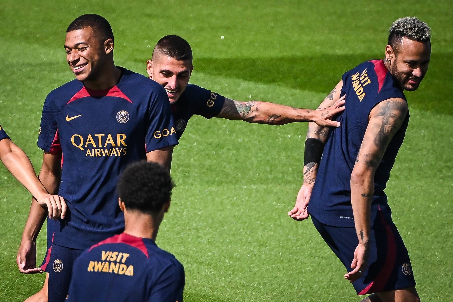 Kylian Mbappé, con Neymar de fondo, sonriente en un entrenamiento con el PSG.