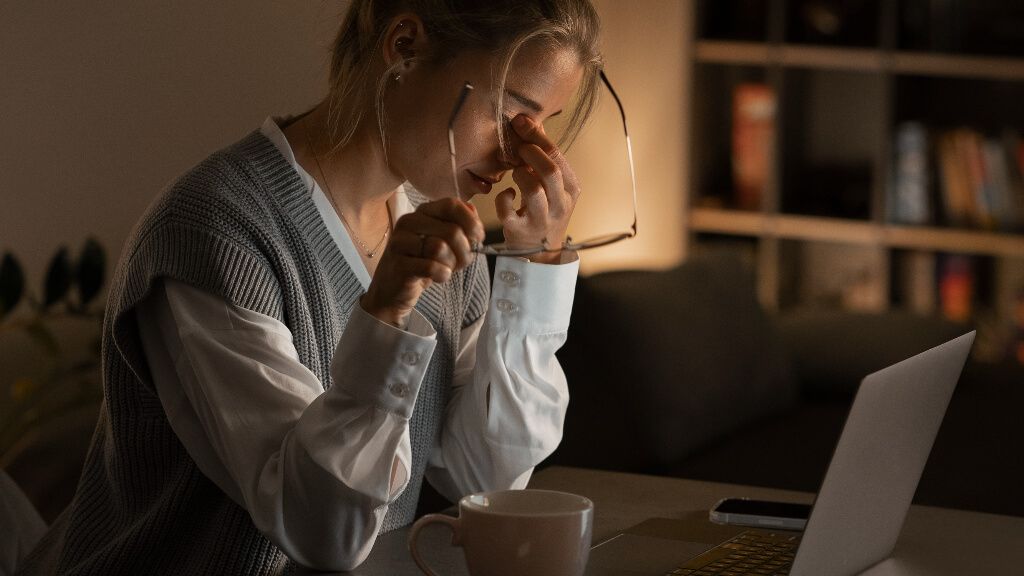 Mujer trabajando de noche con síntomas de cansancio