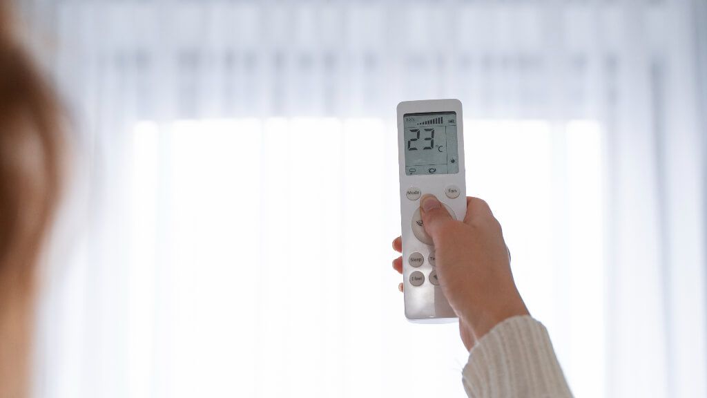  Mujer poniendo el aire acondicionado a 23ºC (Freepik)
