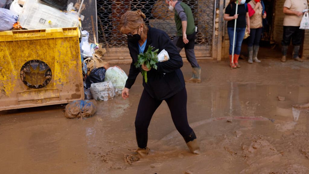  Mujer caminando por una cale de Paiporta, Valencia, con el barro cubriéndole los pies
