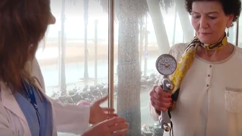 Mujer con cáncer ginecológico sometiéndose a una prueba de fuerza de agarre