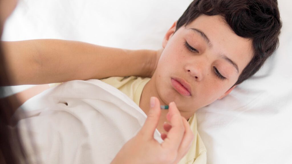  Niño enfermo tomando una pastilla