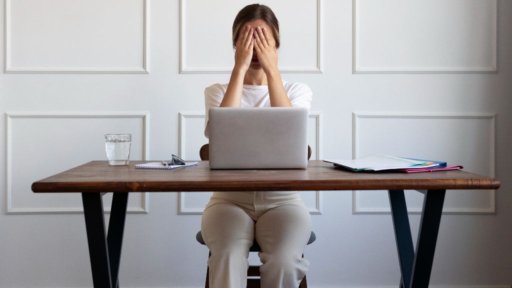 Mujer trabajando con signos de cansancio