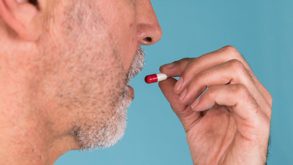  Hombre tomándose una pastilla