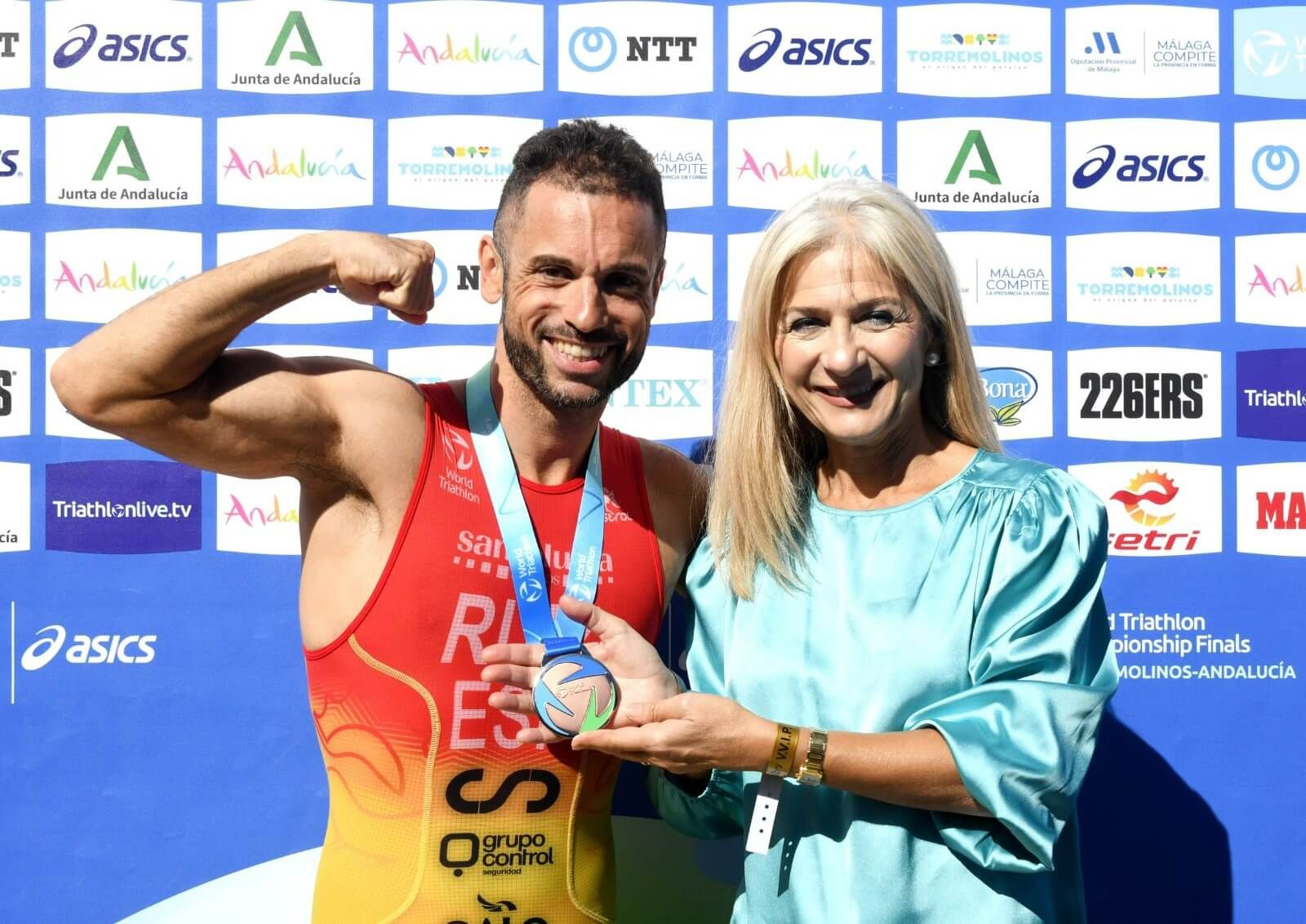  Patricia del Pozo, consejera de Cultura y Deporte de la Junta de Andalucía, posa junto a un triatleta y su medalla.