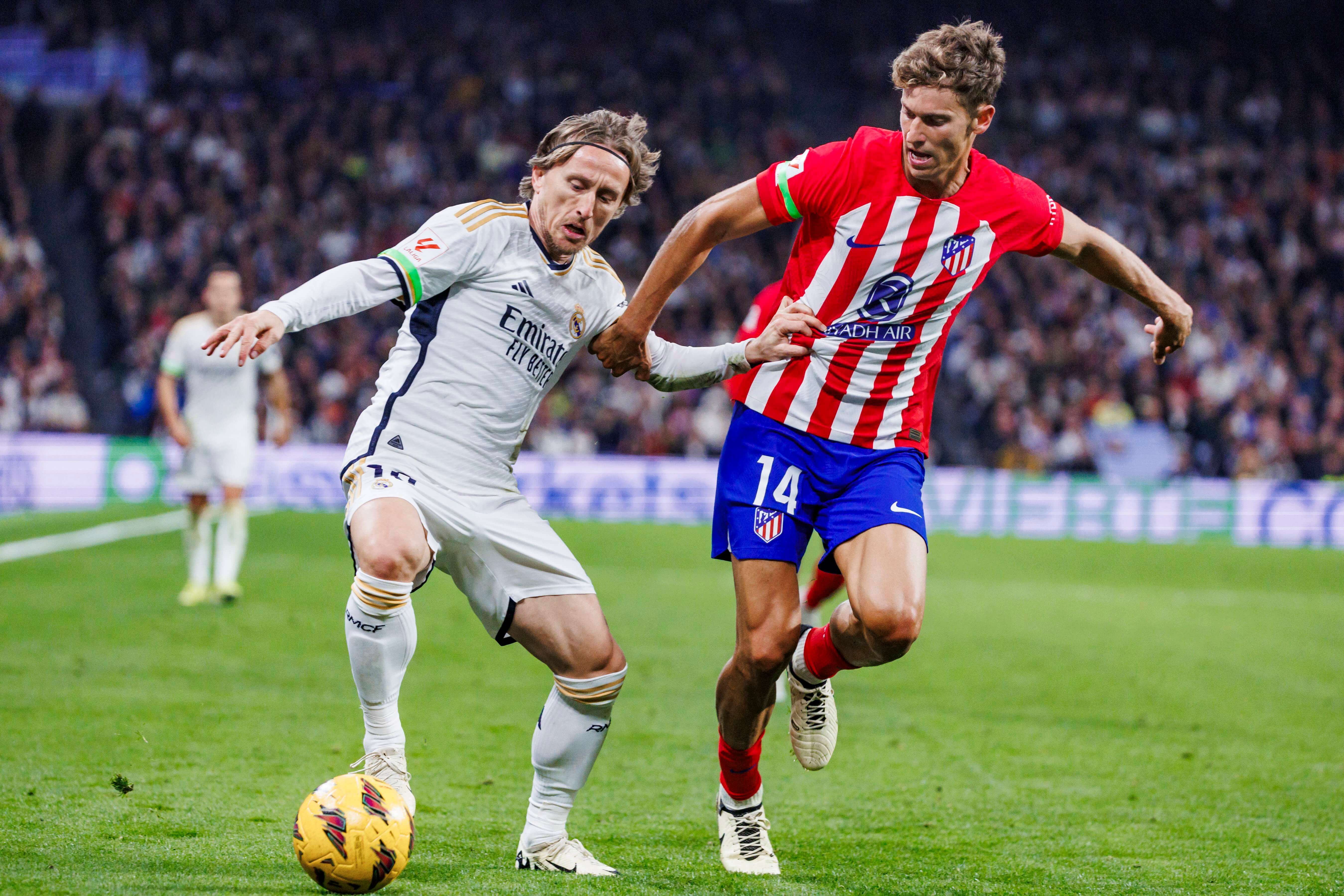 Luka Modric ante Marcos Llorente, durante el derbi entre el Real Madrid y el Atlético. (Foto: Cord