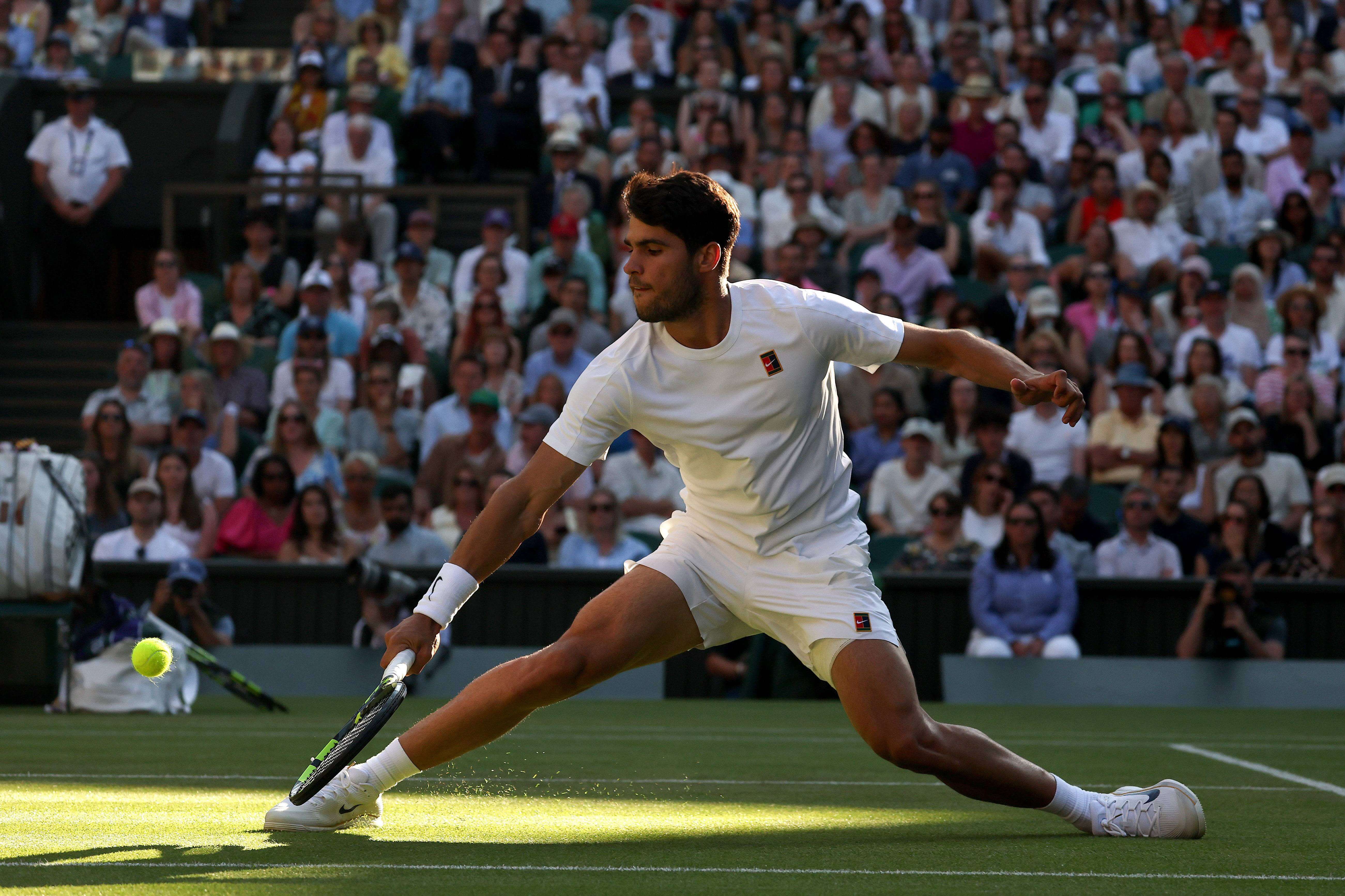  Carlos Alcaraz golpea la bola ante Cameron Norrie en Wimbledon 2025.