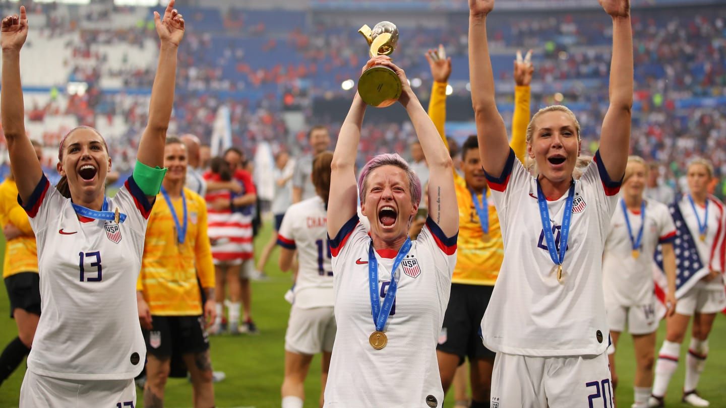 Rapinoe eleva al cielo la copa de campeones del mundo.