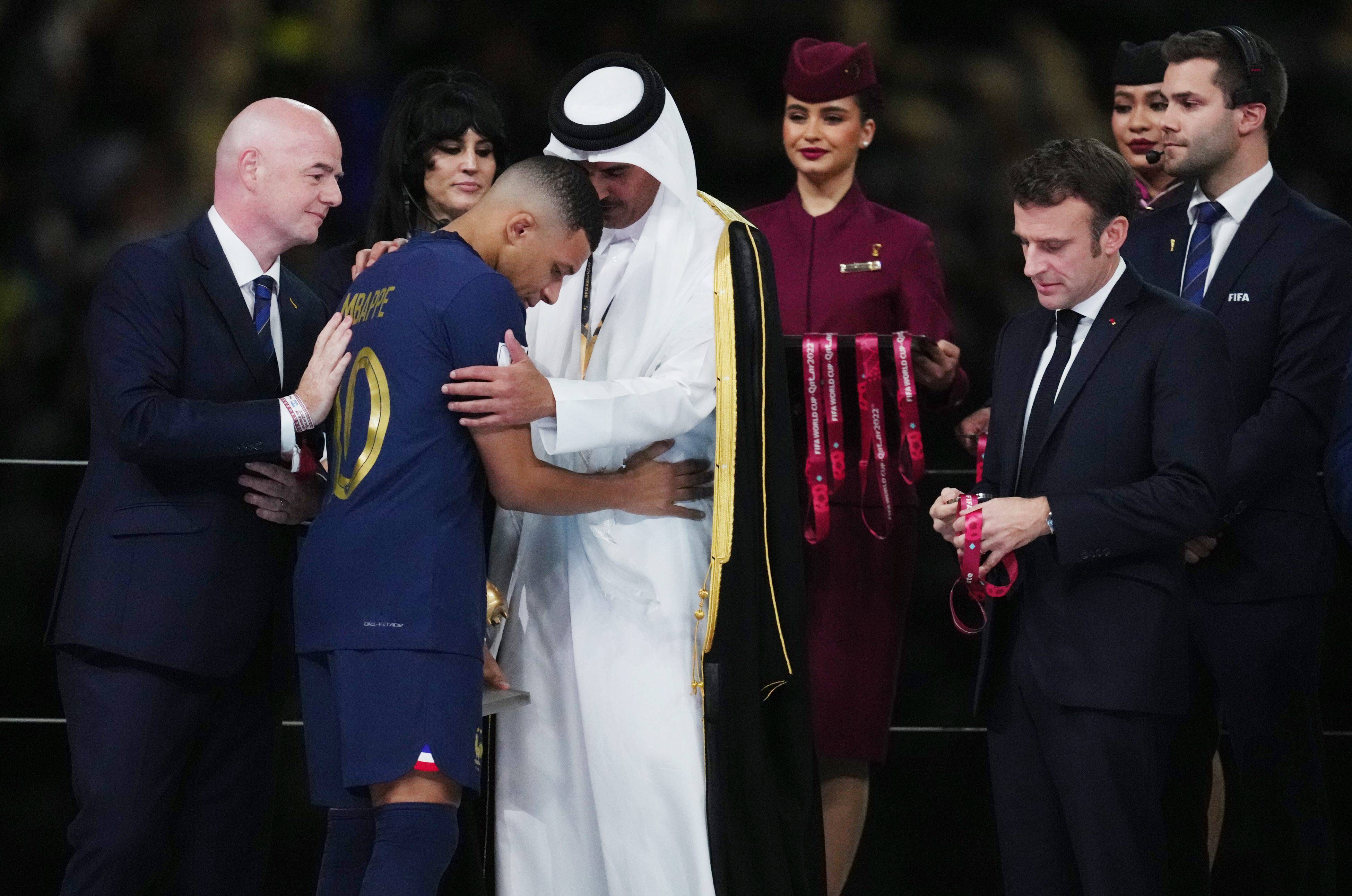  Tamim bin Hamad Al Thani, emir de Qatar, junto a Gianni Infantino, le entrega una medalla a Kylian