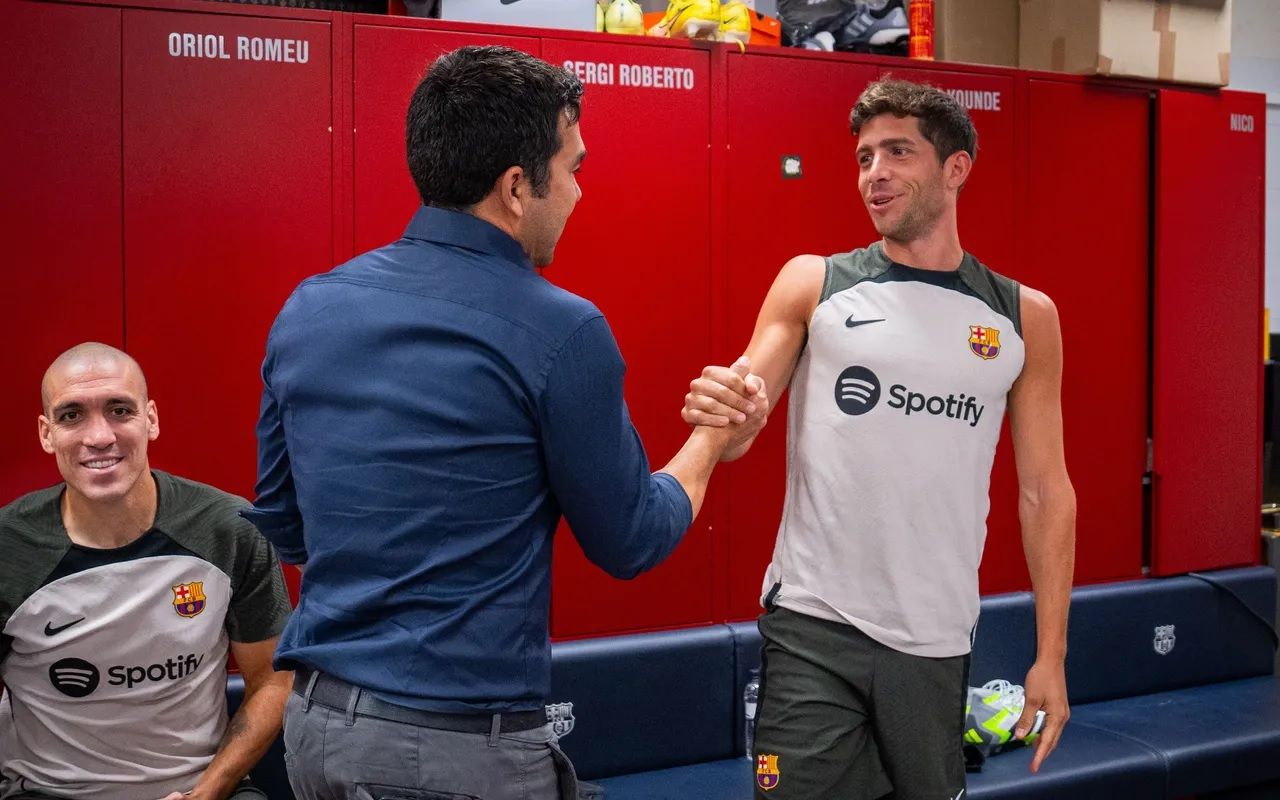  Deco saluda a Sergi Roberto en el vestuario.