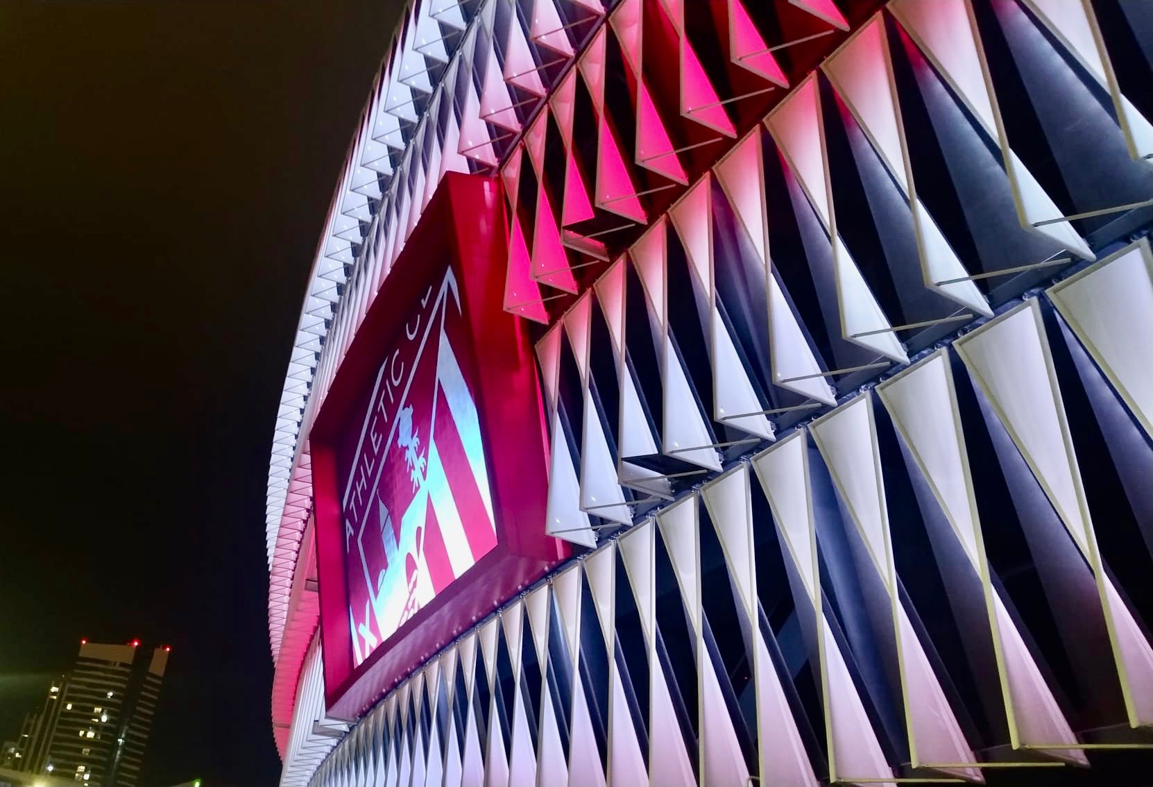 Bonito plano nocturno del escudo en la fachada de San Mamés, donde se dará el One Club Man el 27 de septiembre.