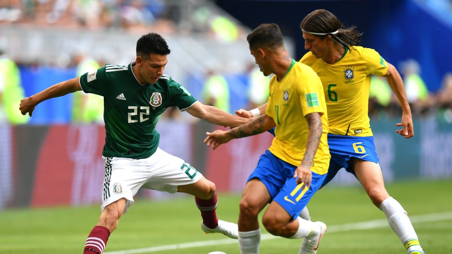 Filipe Luis intenta arrebatar un balón a Hirving Lozano.