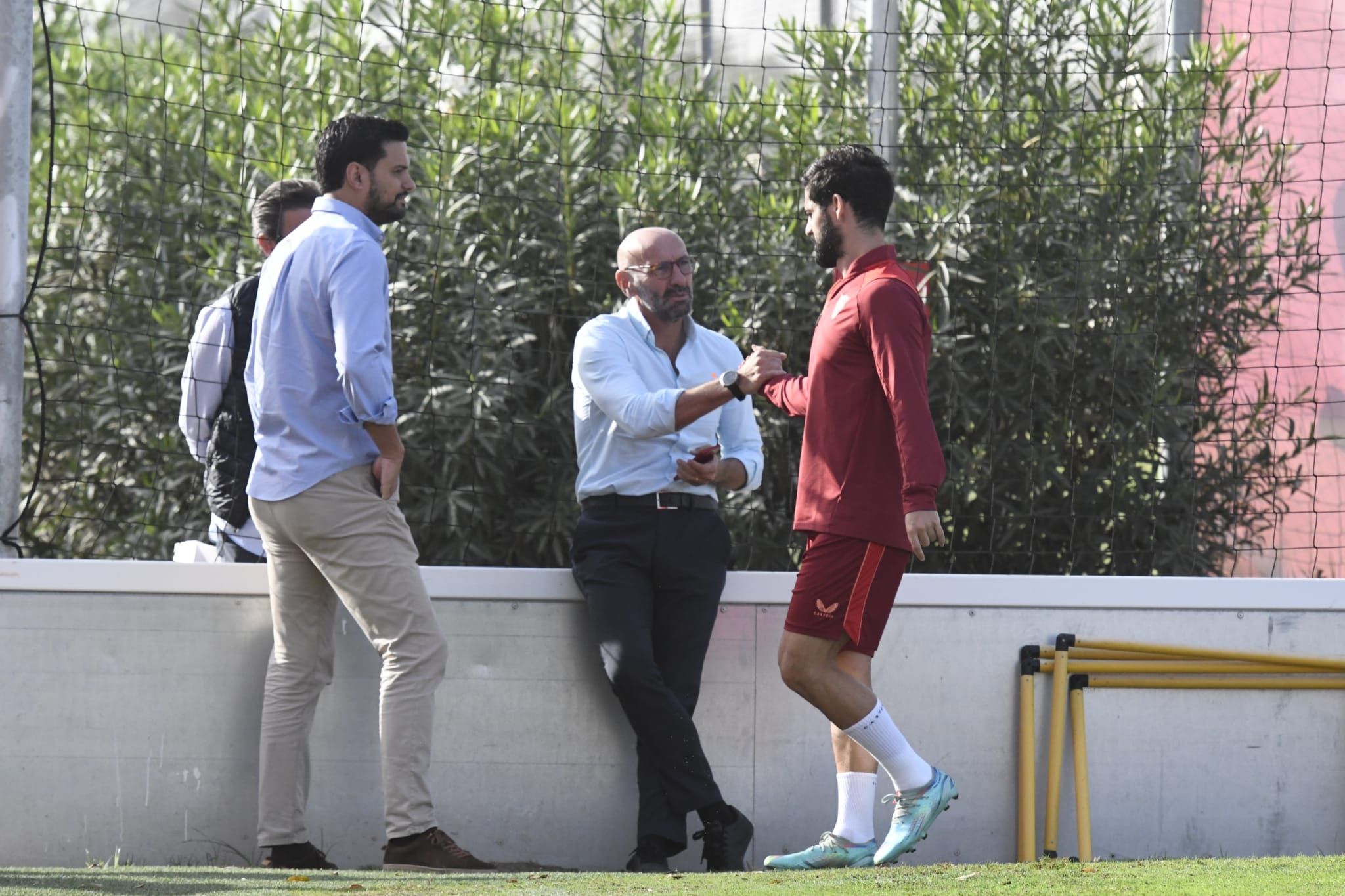  Isco saluda a Monchi tras marcharse cojeando de un entrenamiento.