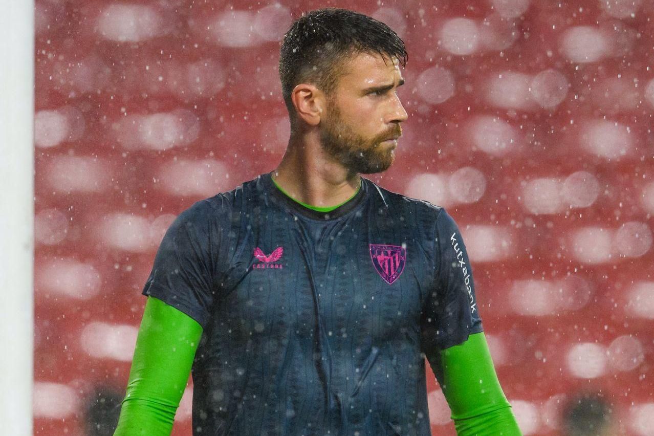 El guardameta internacional Unai Simón calienta bajo la lluvia.