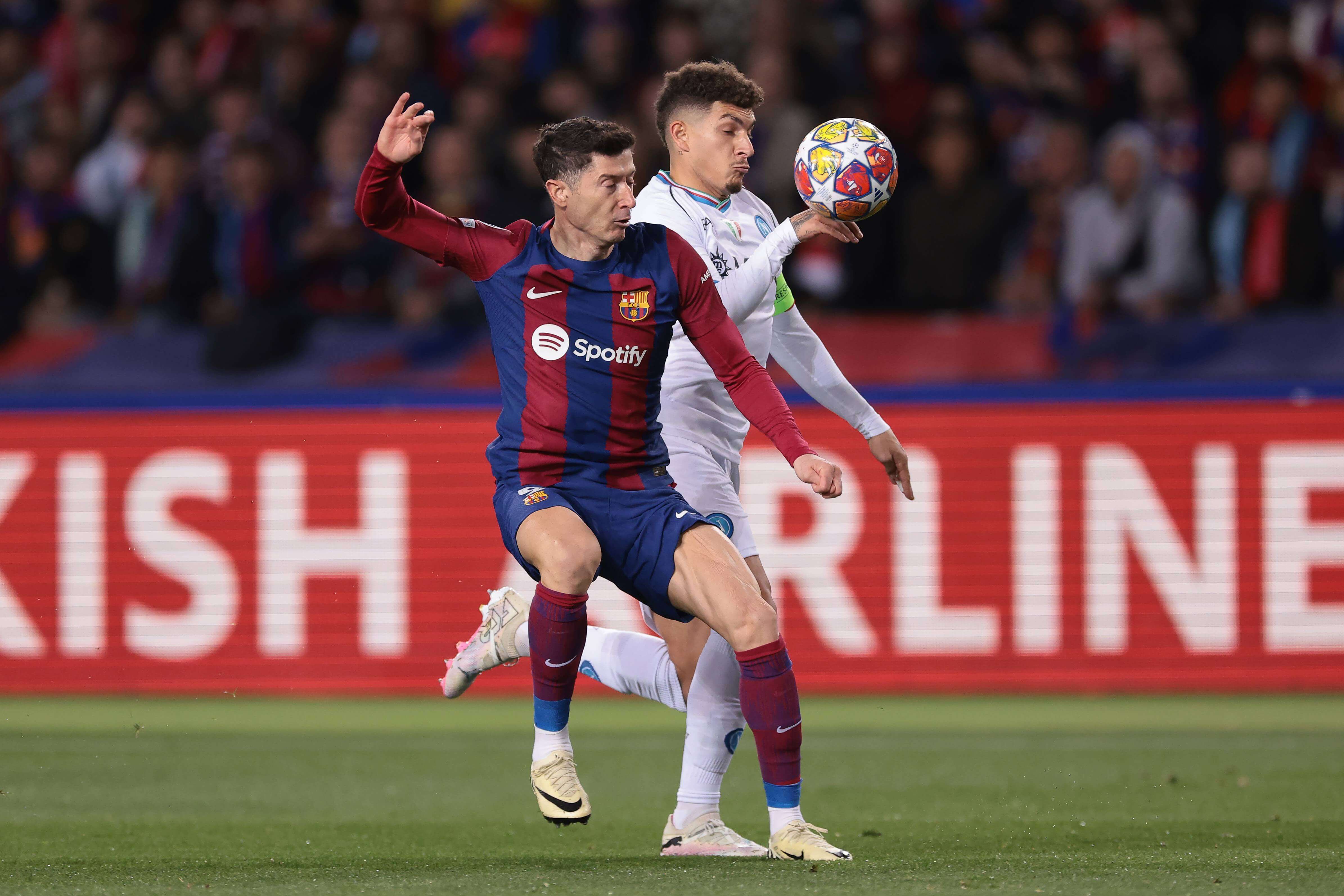  Di Lorenzo pelea un balón con Lewandowski en la Champions.