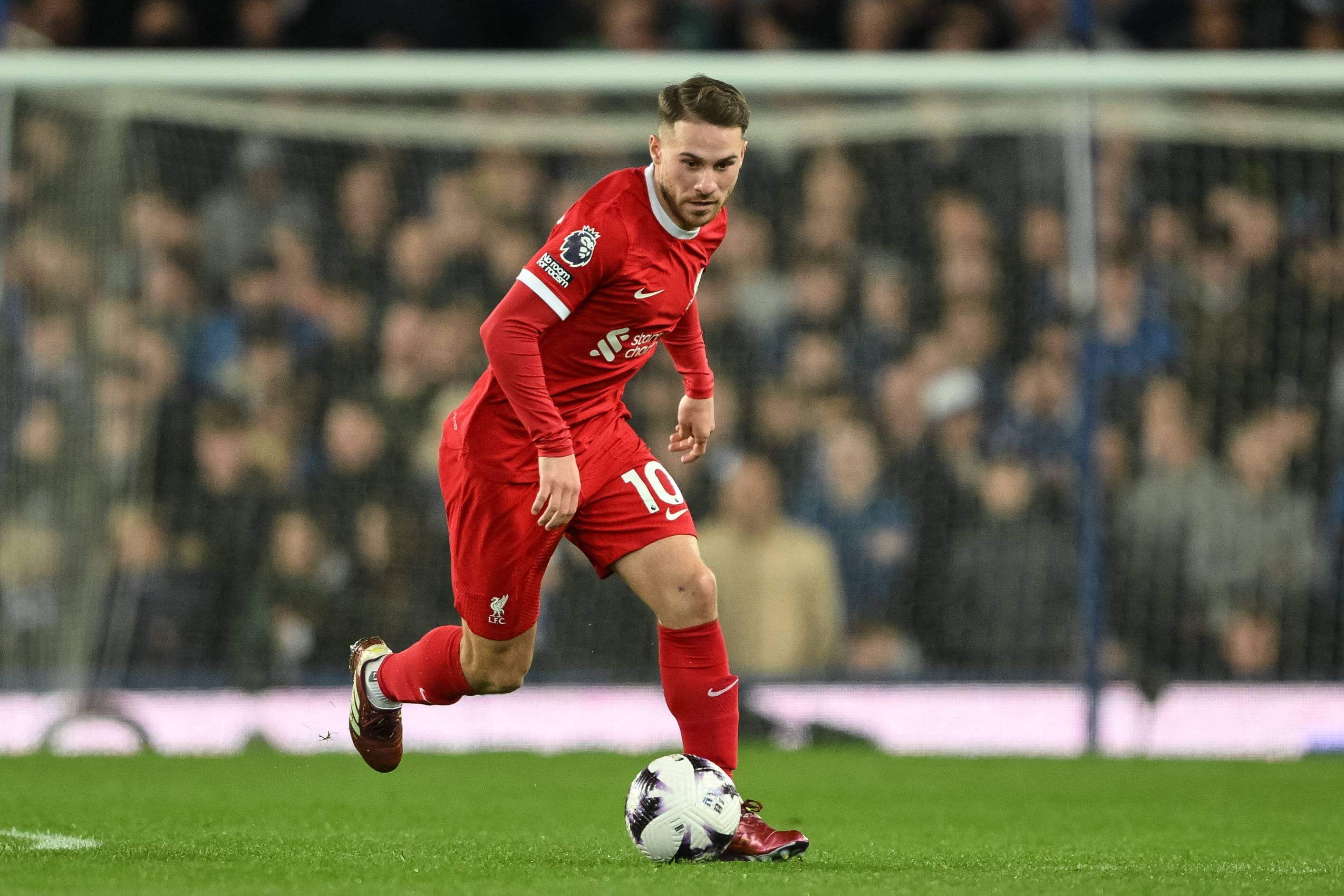 Mac Allister conduce un balón con la camiseta del Liverpool.