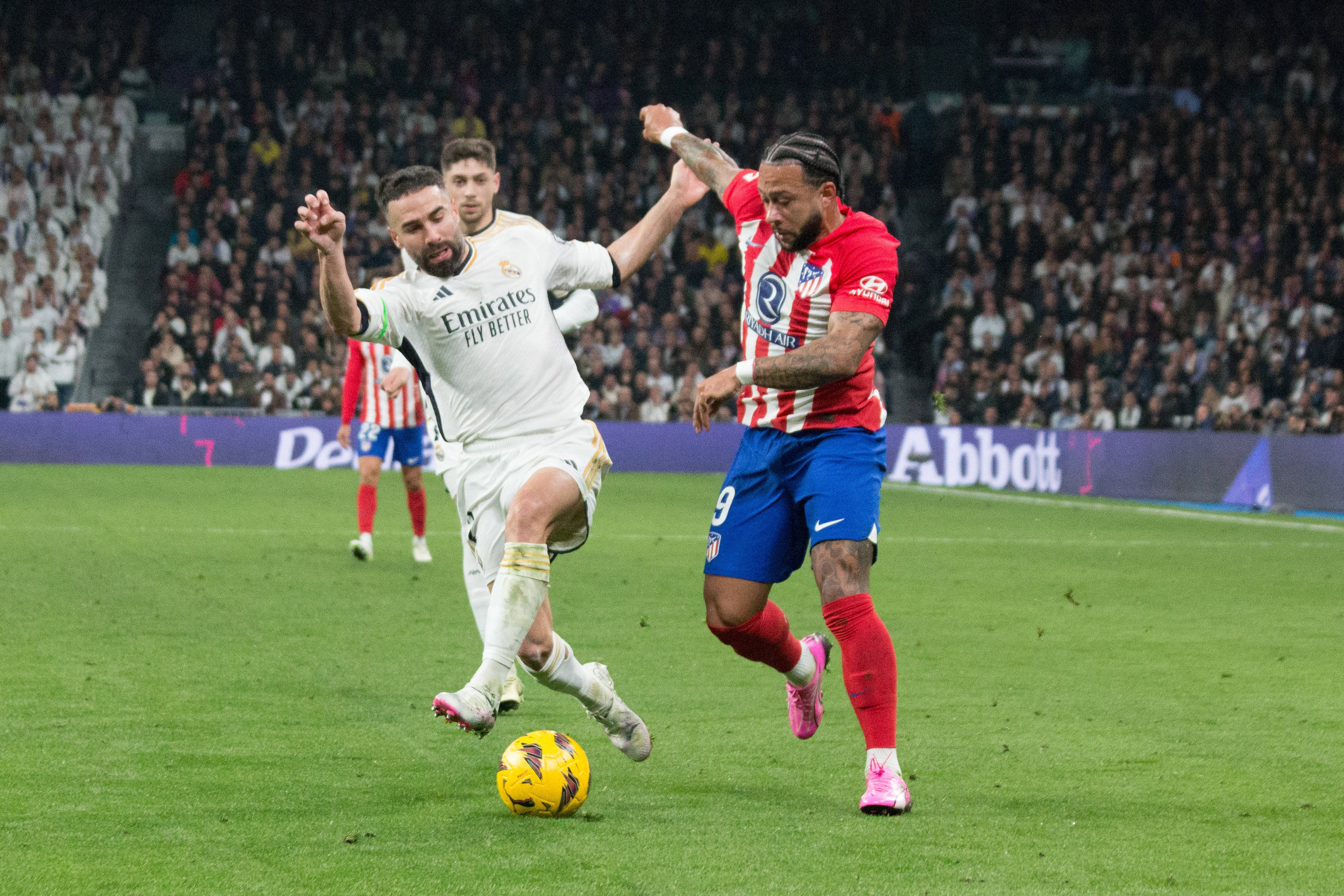  Dani Carvajal y Memphis Depay luchan por un balón en el derbi.