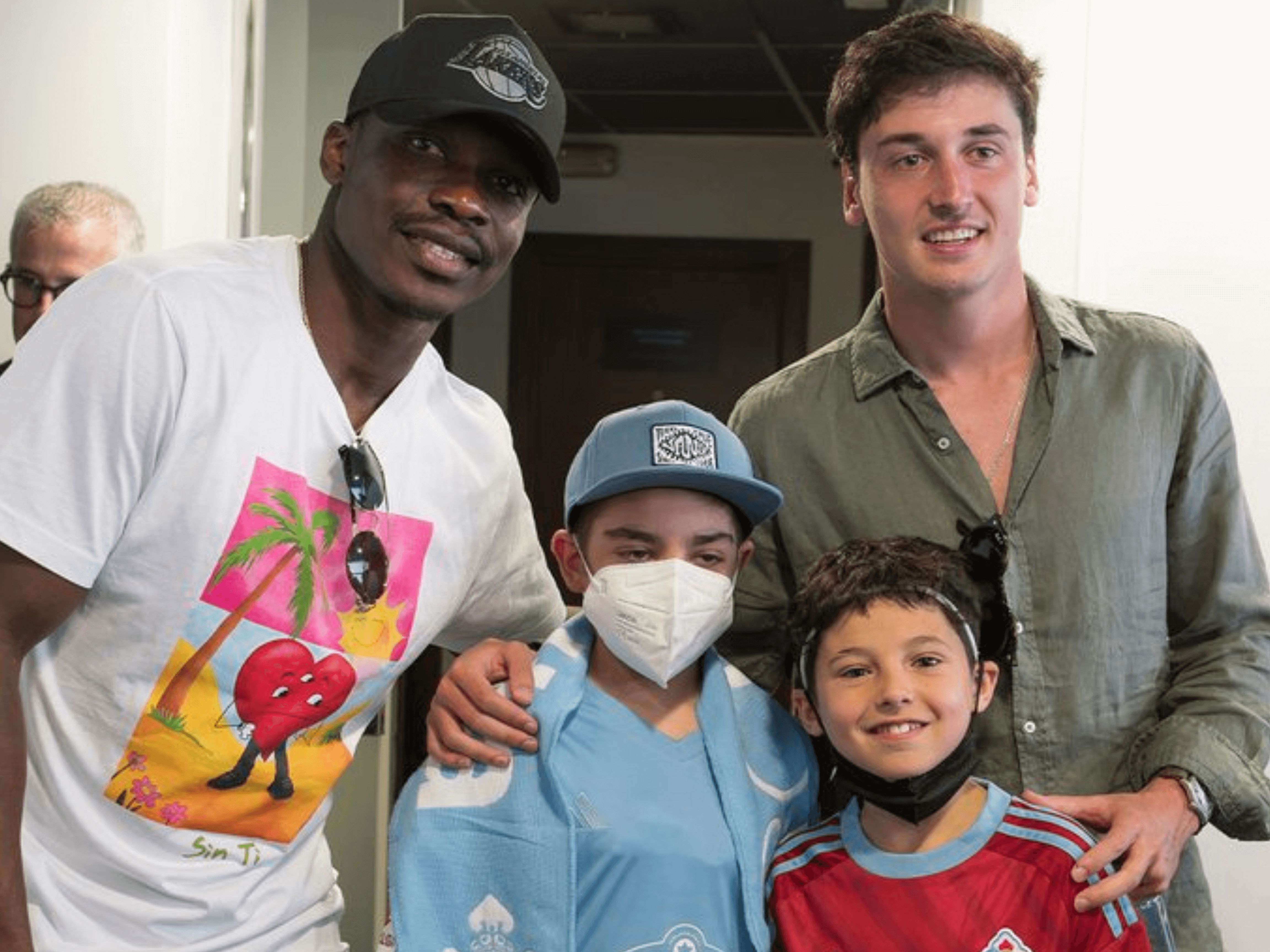  Aidoo y Dotor haciéndose una foto con dos niños.
