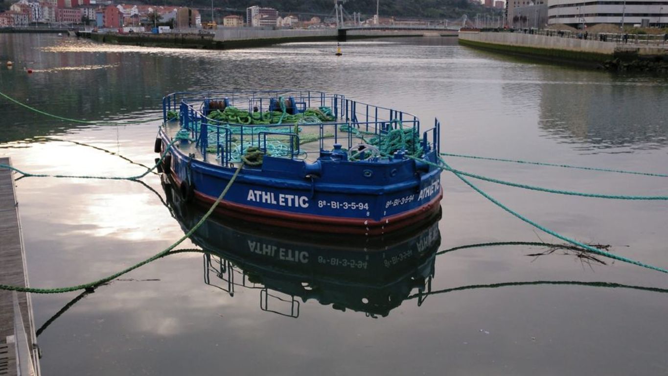 La gabarra Athletic reposa mansamente en aguas de la Ría de Bilbao.