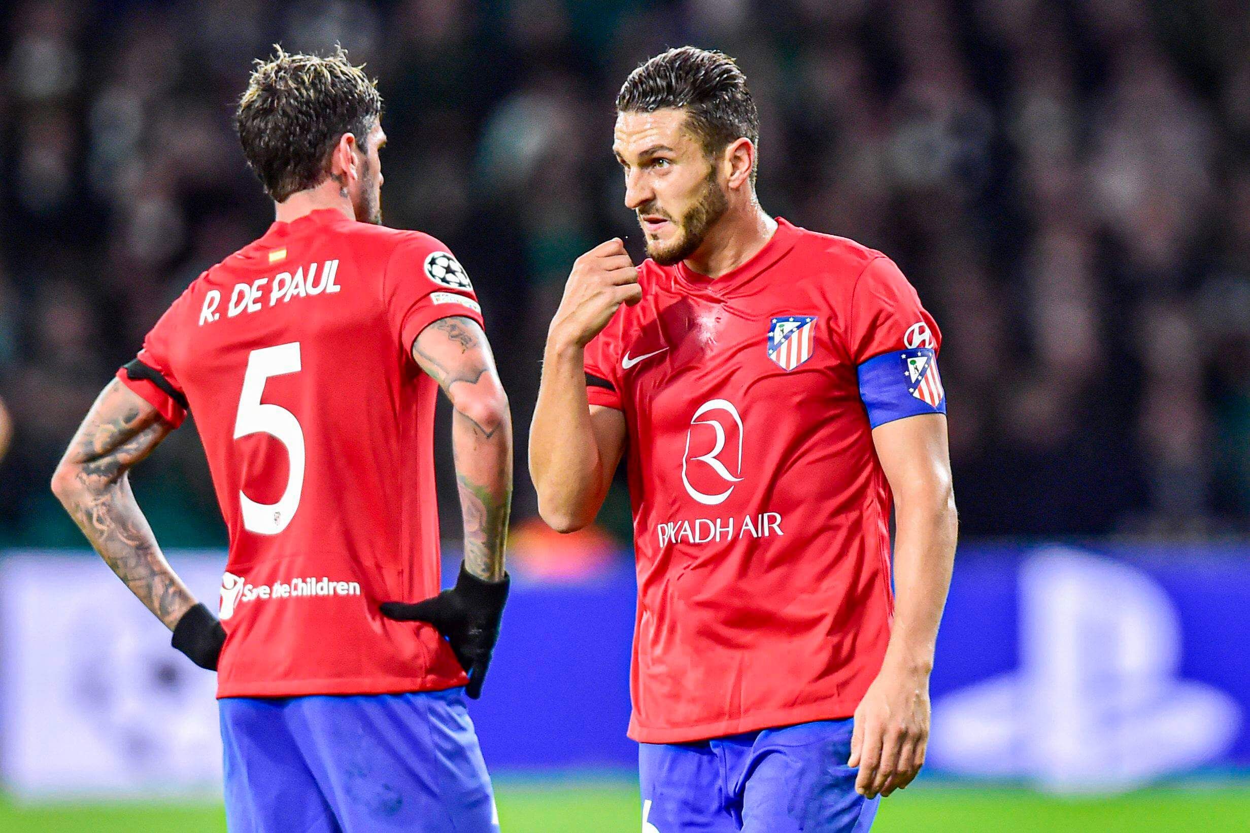 Koke y De Paul, hablando en un partido de Champions.