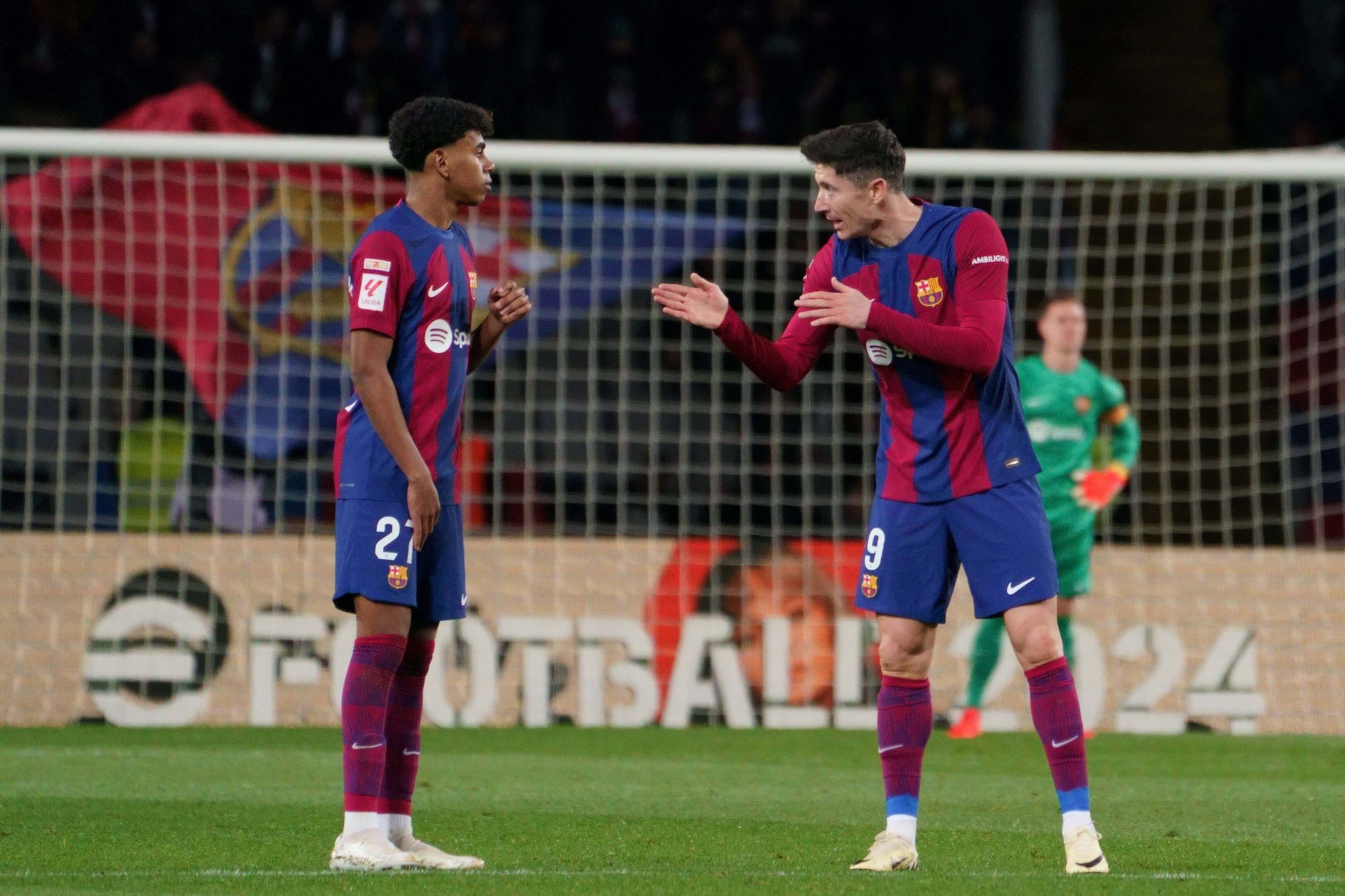 Robert Lewandowski charla con Lamine Yamal durante un partido del Barcelona.