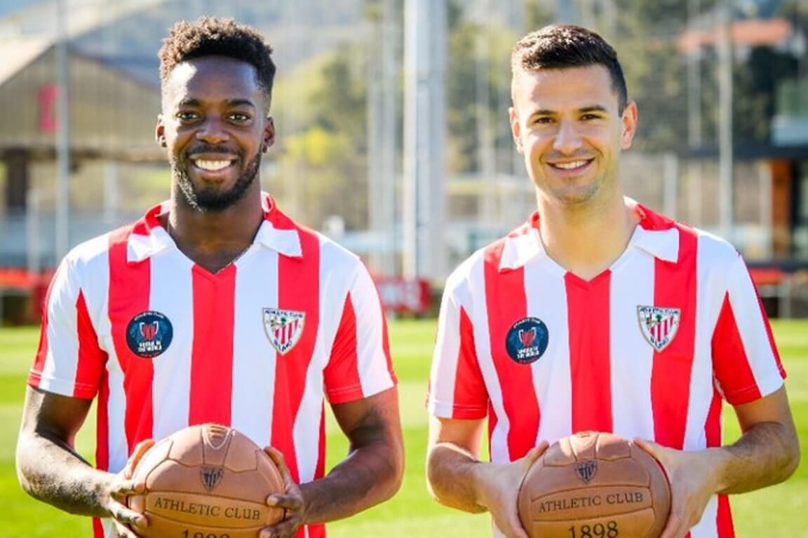 Iñaki Williams y Gorka Guruzeta posan con la nueva camiseta retro del Athletic Club por la final de Copa, conmemora la de 1984.