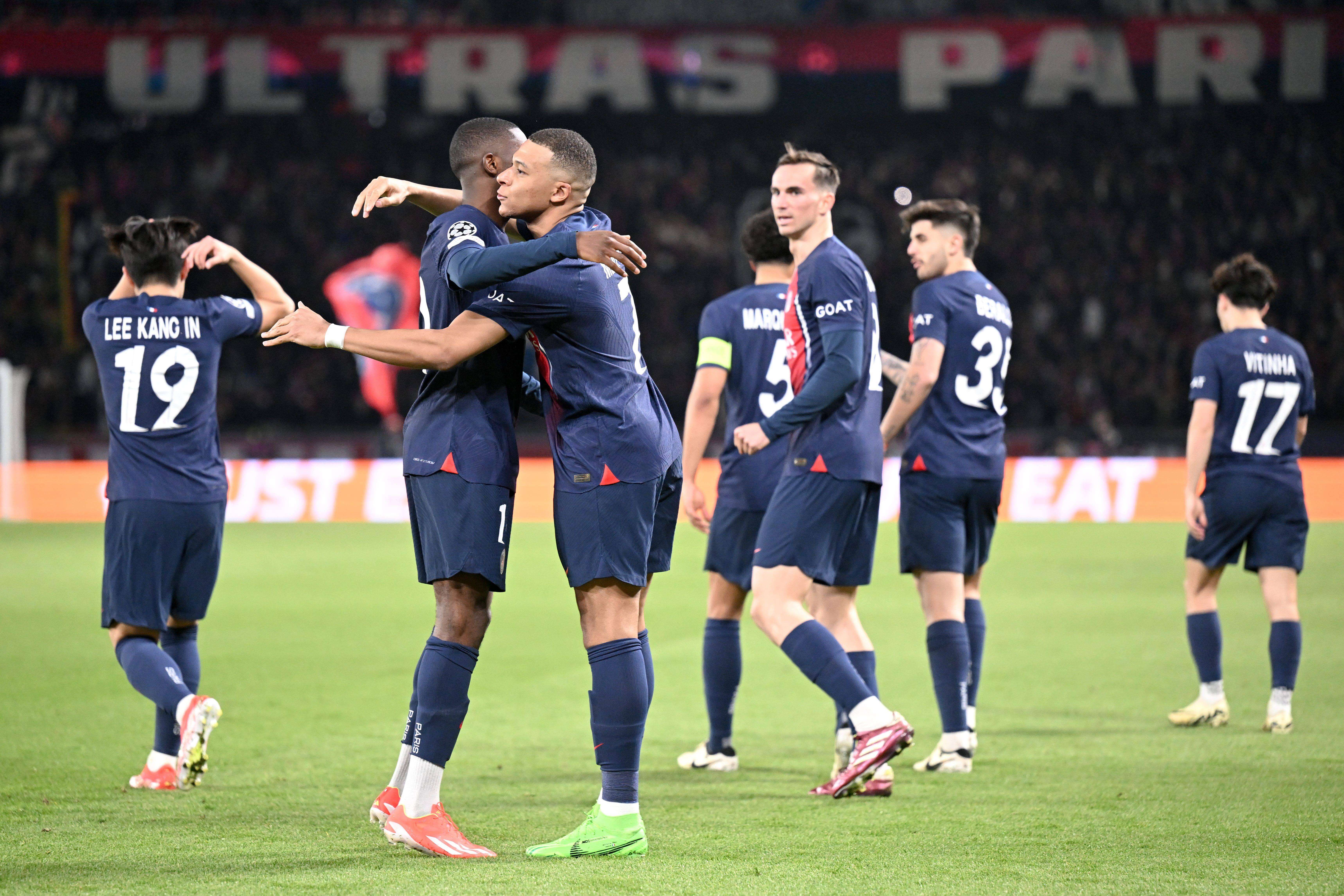 Dembéle se abraza con Mbappé tras marcar al Barça.