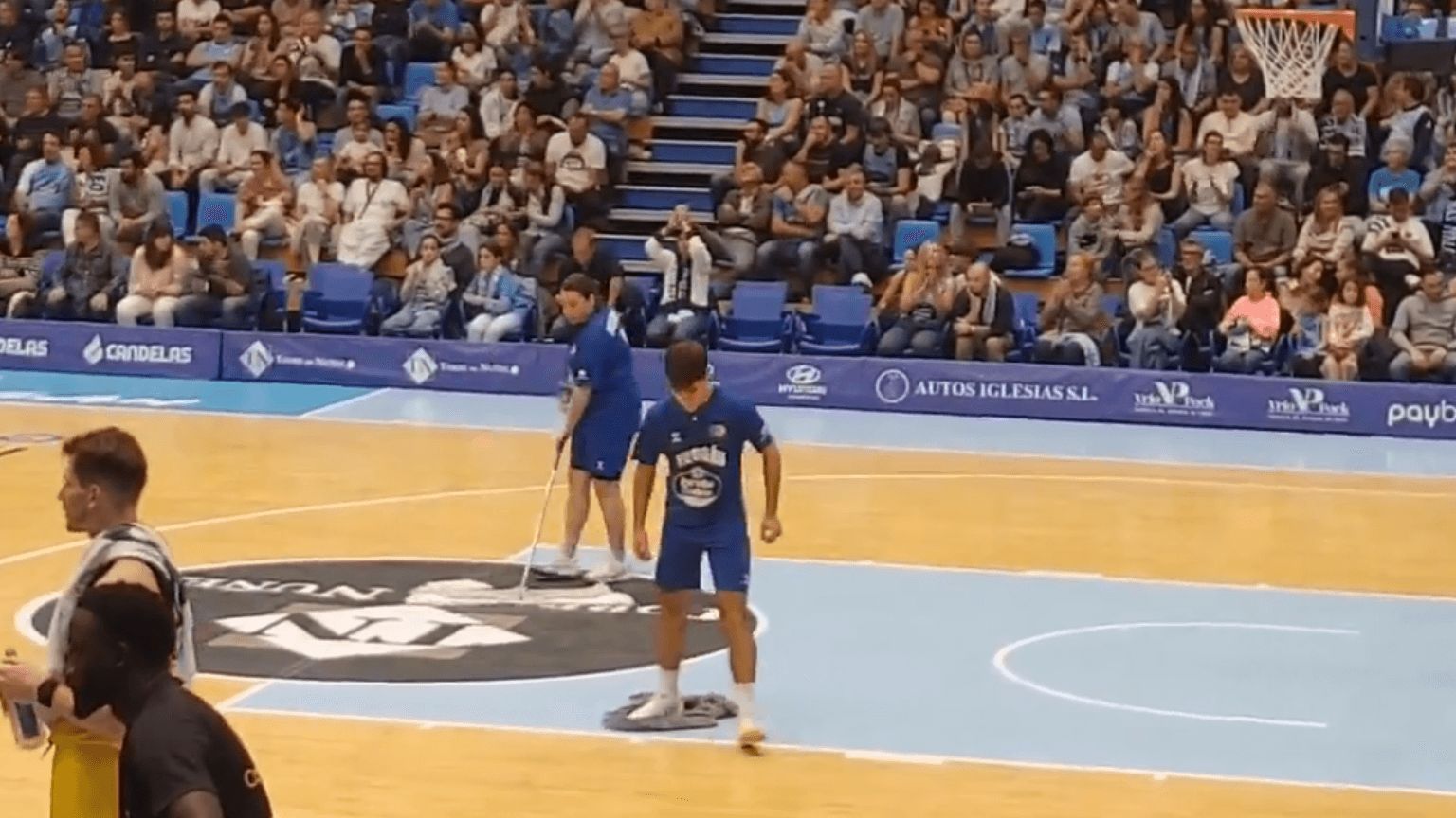  Operarios ayudan a secar la pista del Pazo dos Deportes