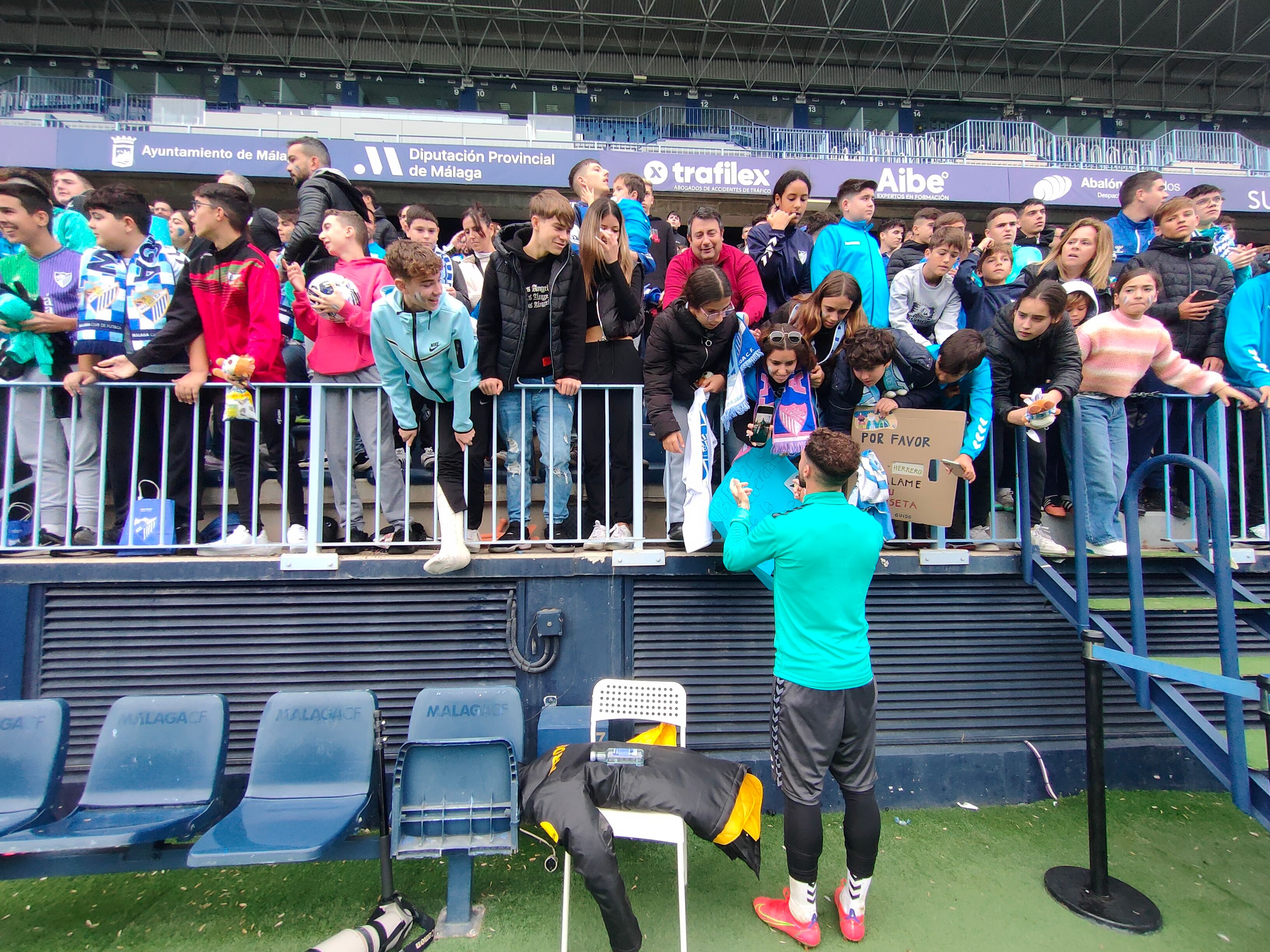 Dani Sánchez firma una pancarta a una pequeña malaguista. (A.F.)