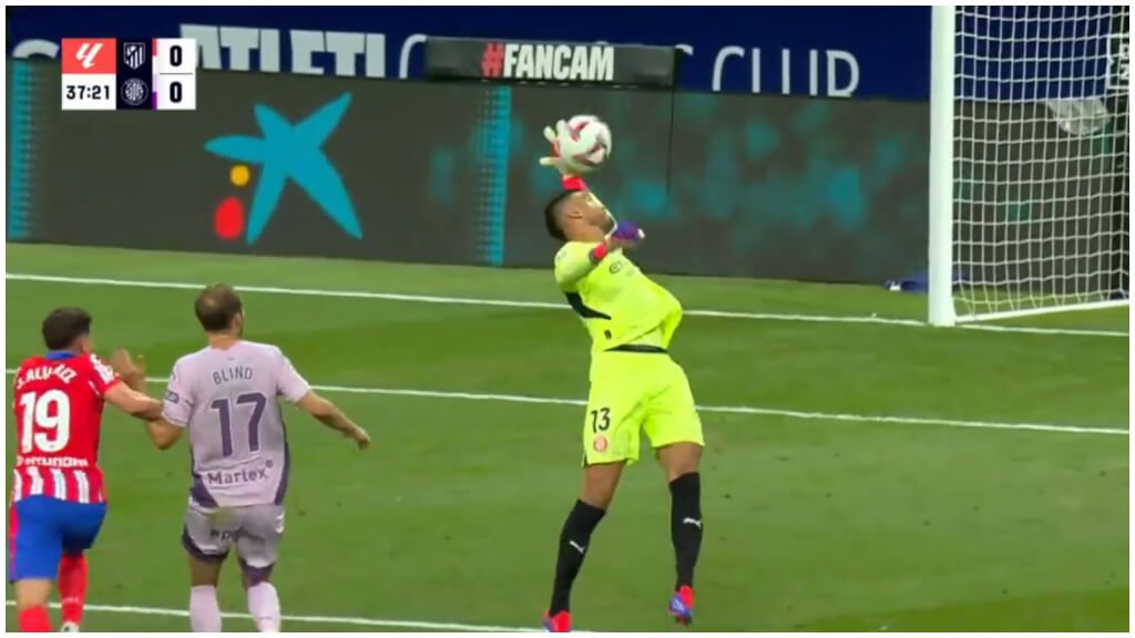  Gazzaniga la toca con la mano fuera del área. A la izquierda de la imagen, Blind disputa el balón (DAZN)