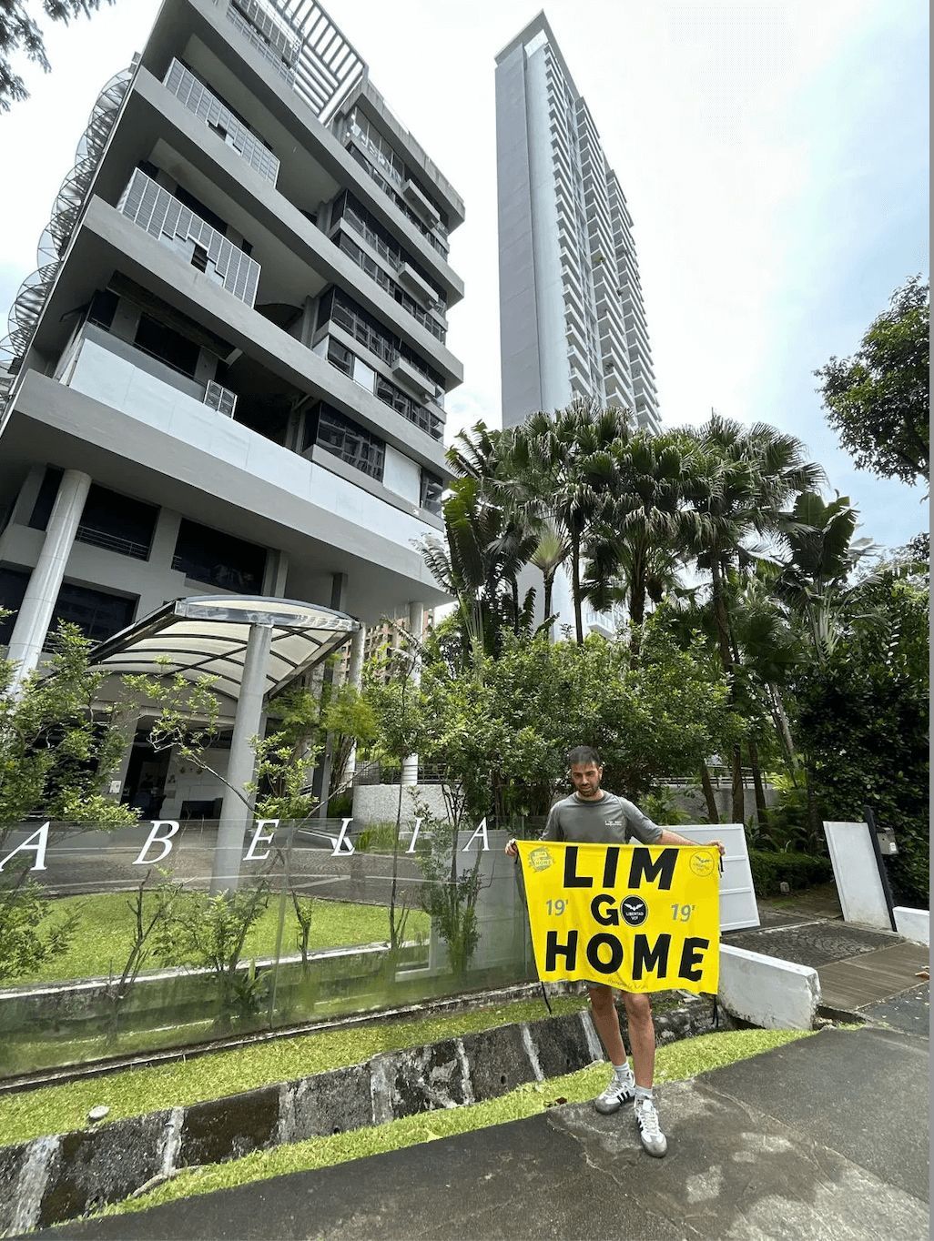  Imagen del aficionado valencianista con el cartel delante de un hotel propiedad de Peter Lim en Sin