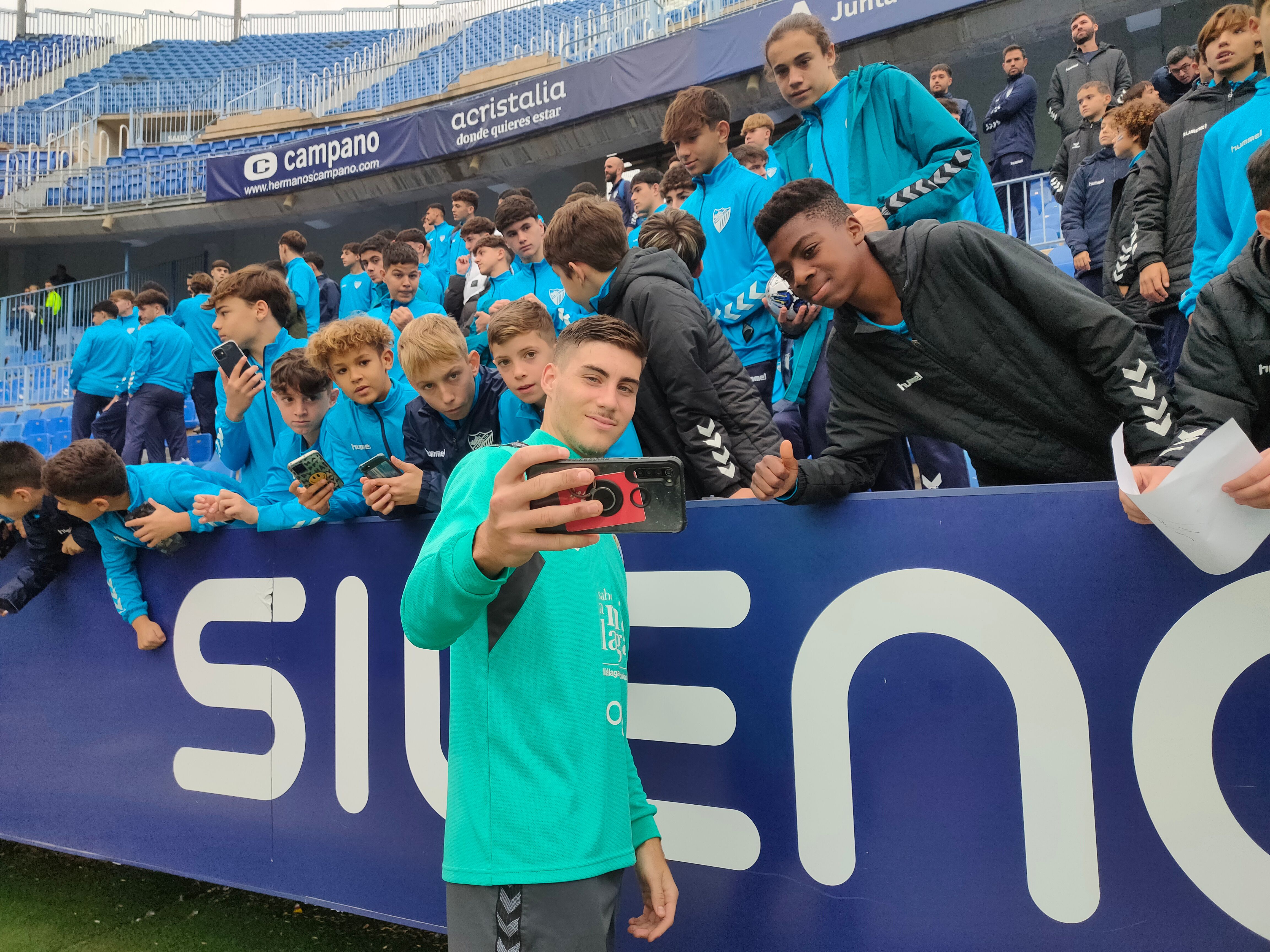 Foto de Roberto con los pequeños canteranos del Málaga. (A.F.)