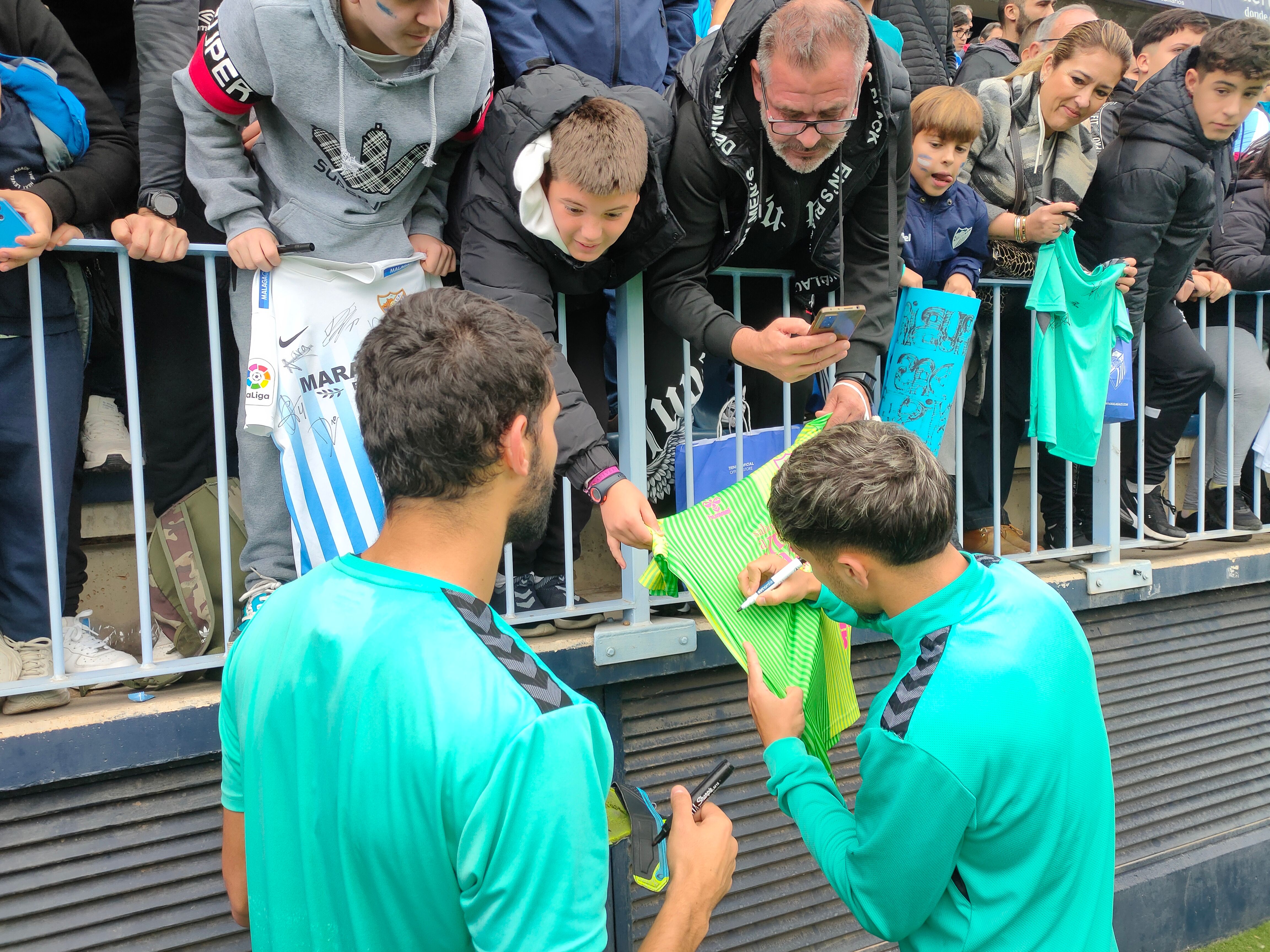 Einar y Kevin firman camisetas. (A.F.)