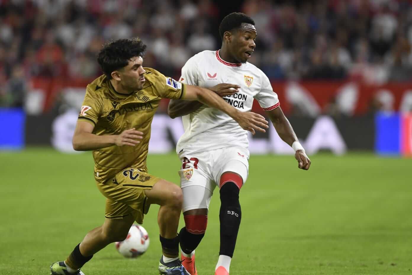  Jon Aramburu trata de defender a un jugador del Sevilla.