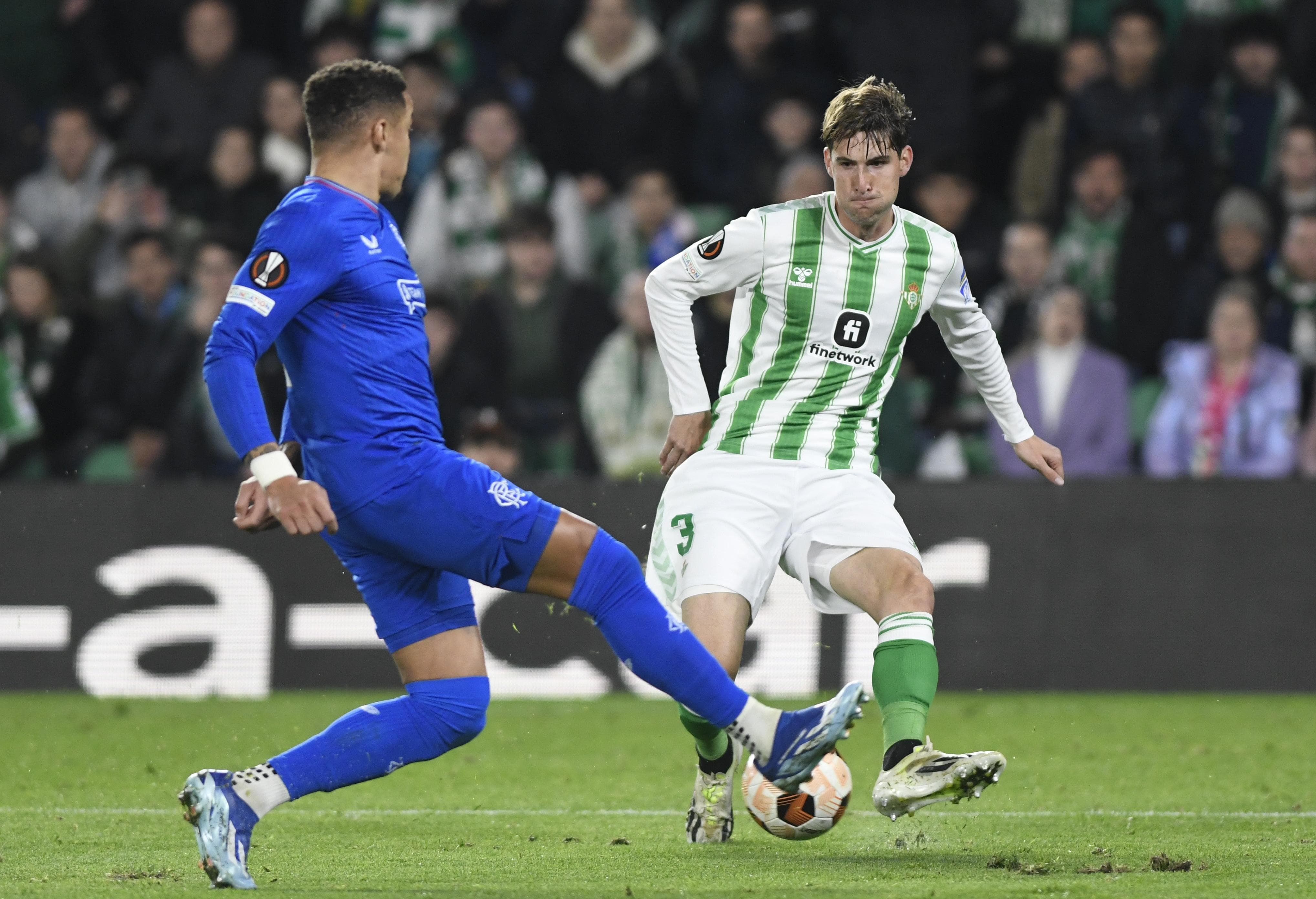 Juan Miranda centra un balón en un partido del Betis.