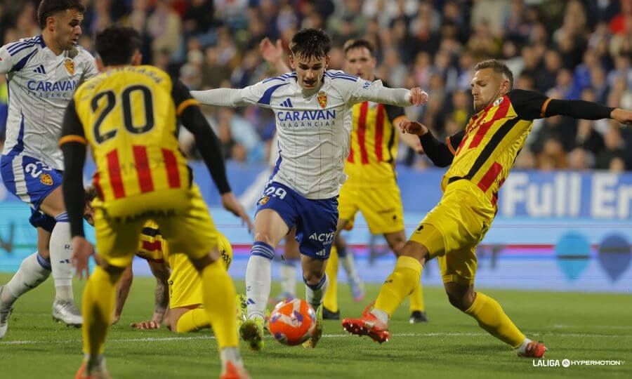 Pau Sans conduce el balón entre sus rivales en el Real Zaragoza-Huesca.