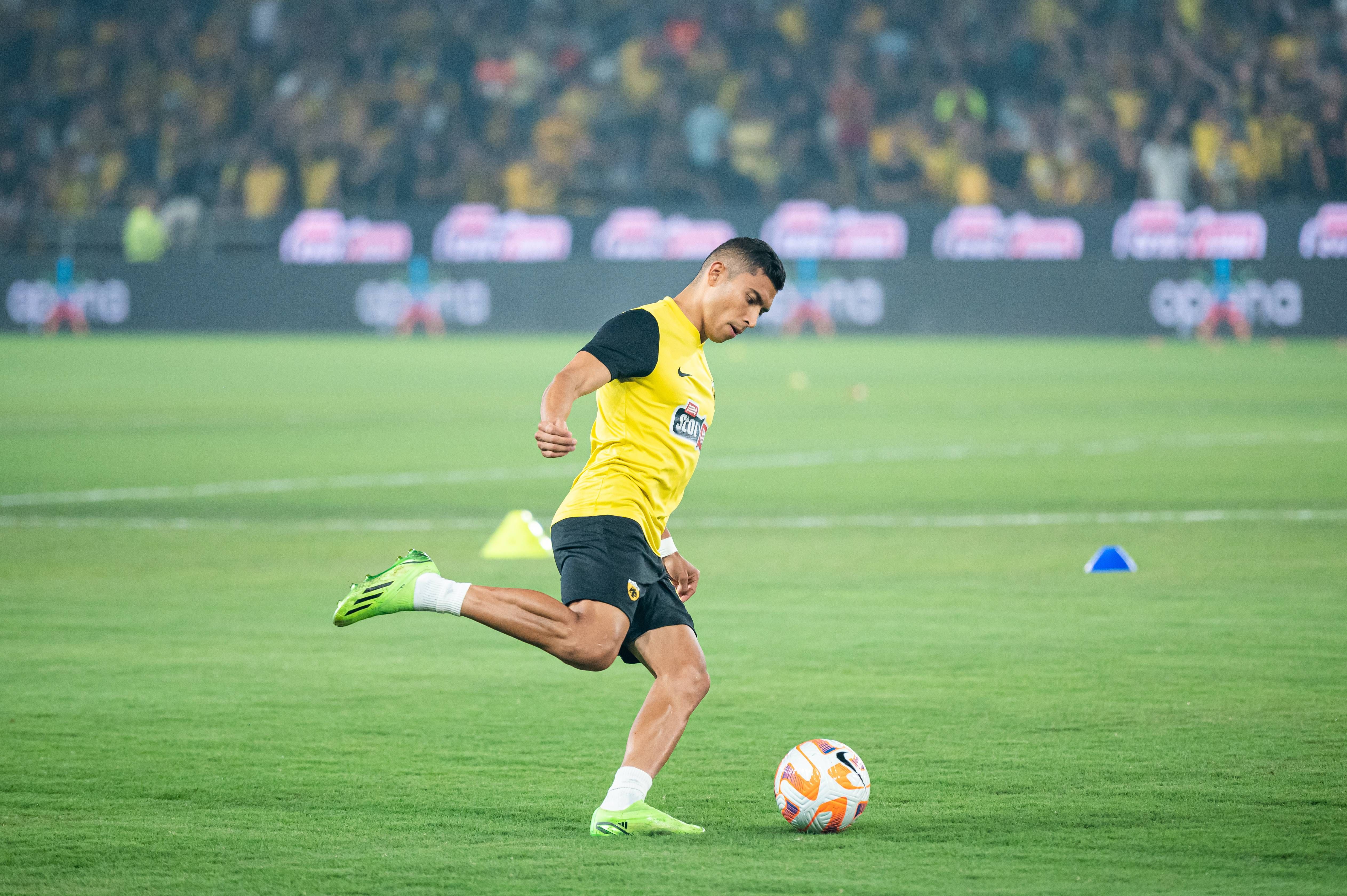 Orbelín Pineda calienta con el AEK de Atenas.