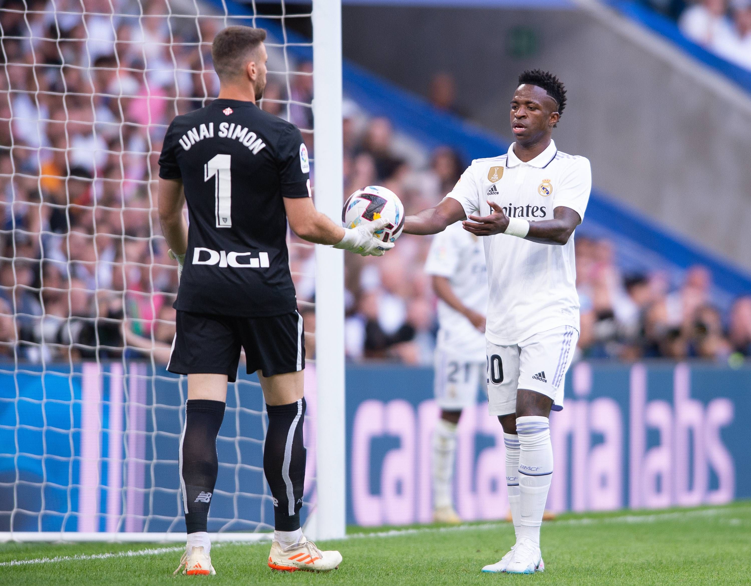 Unai Simón entrega el balón a Vinícius JR en un partido Real Madrid - Athletic Club.