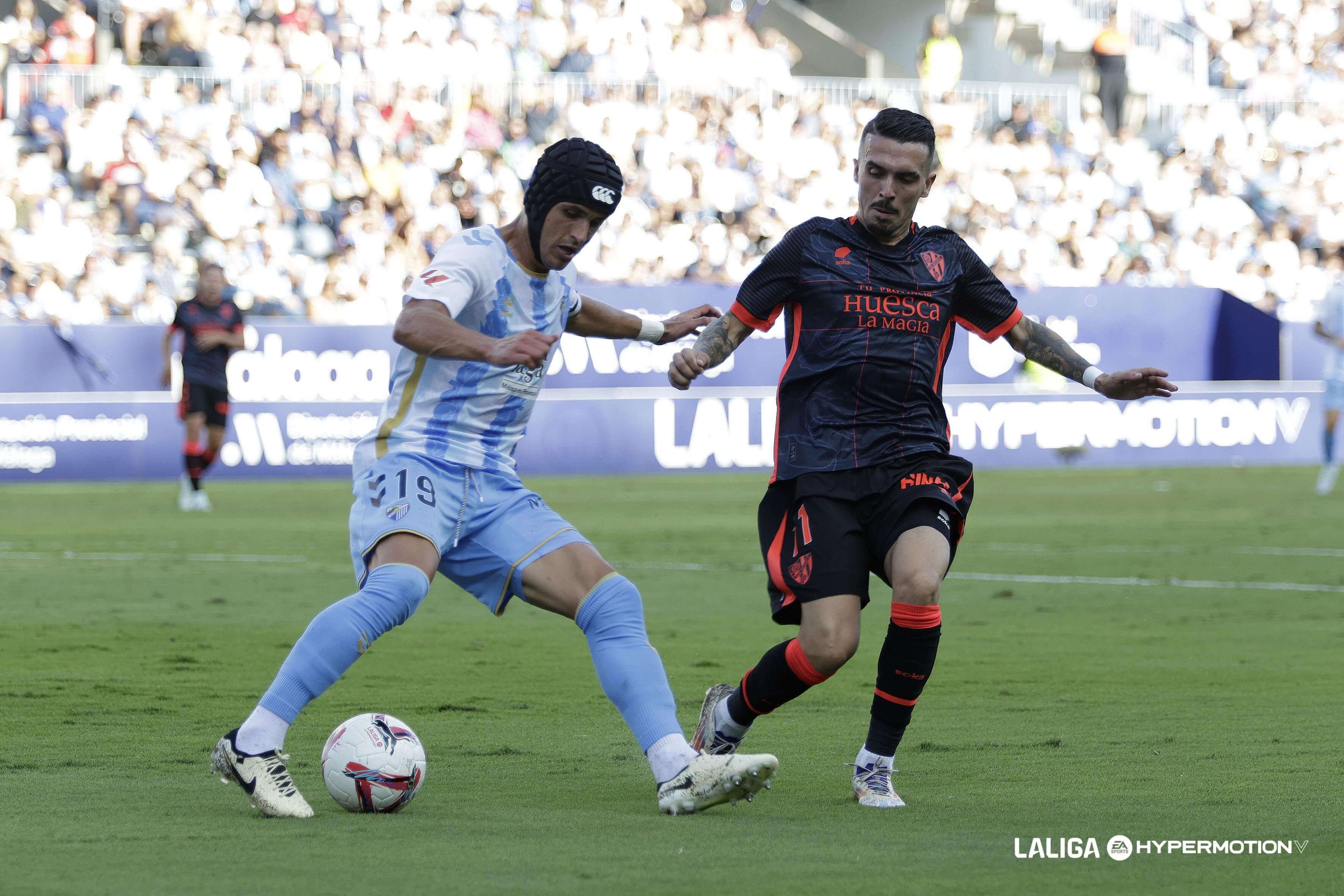 Luismi Sánchez protege el balón en el Málaga - Huesca.