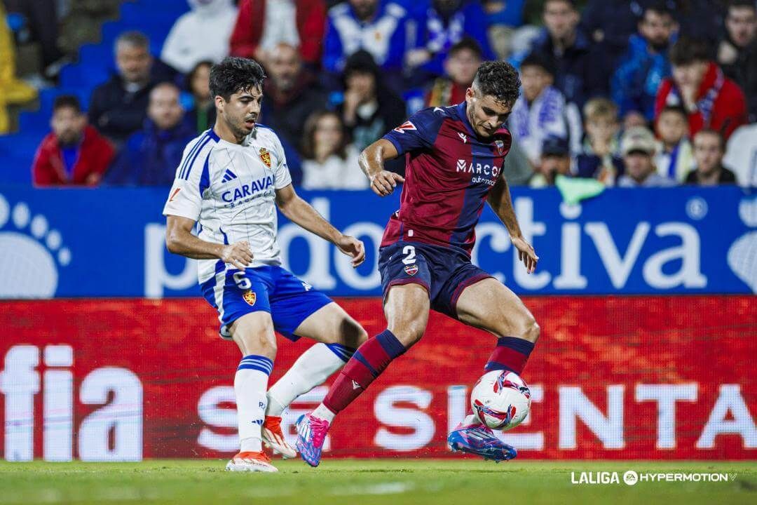 Andrés García controla delante de Enrique Clemente en el Real Zaragoza-Levante.
