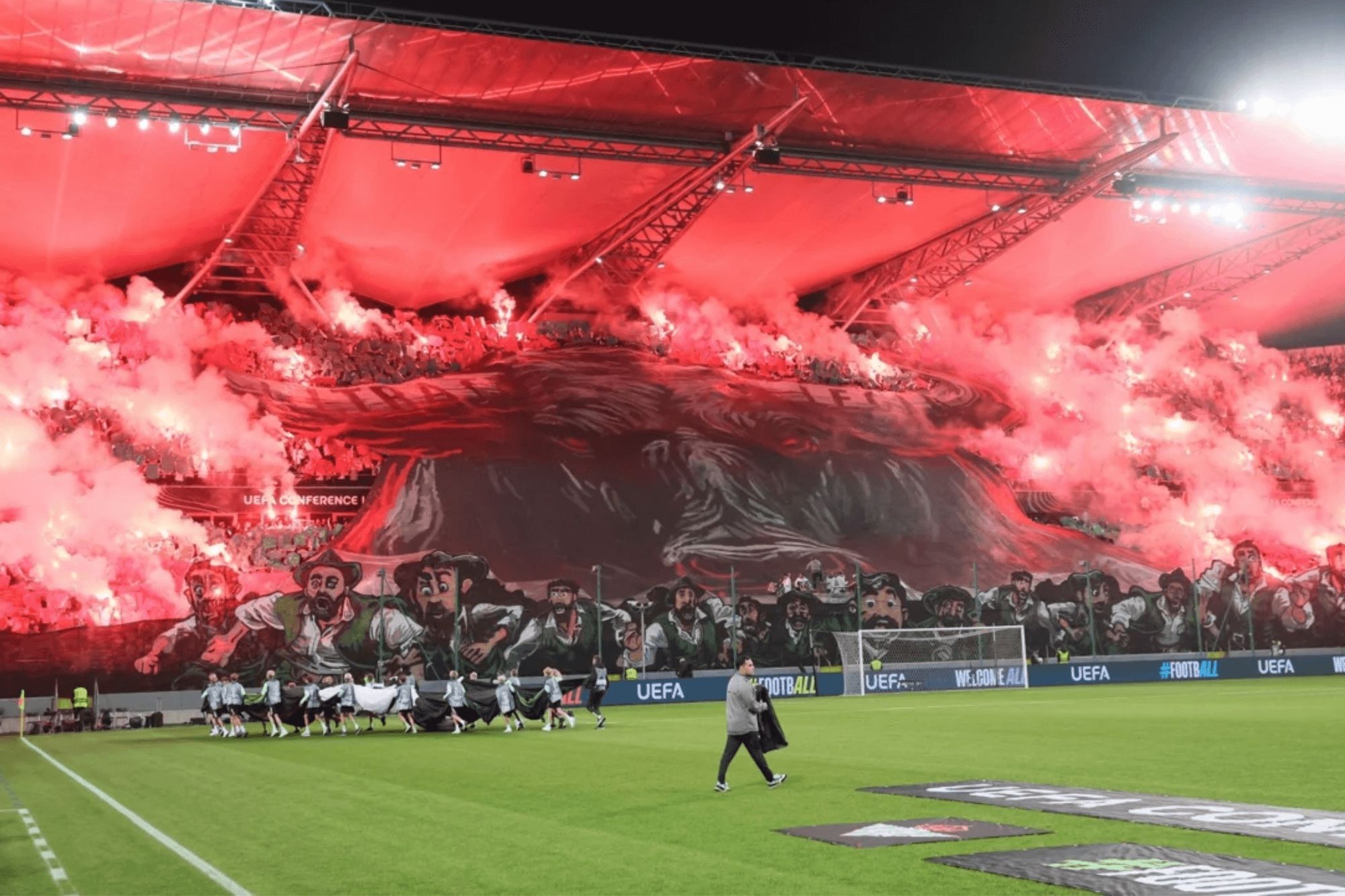 Tifo con la imagen de un toro y múltiples bengalas en el Legia-Betis.