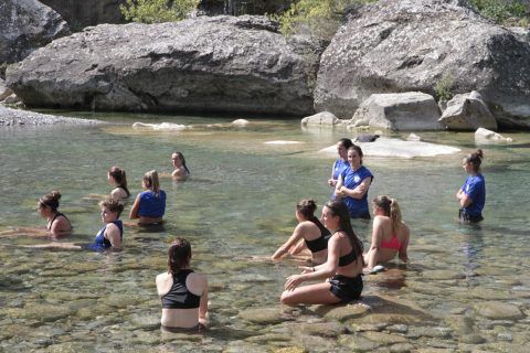 Las jugadoras relajan las piernas en las pozas del río Ara tras a sesión matinal.