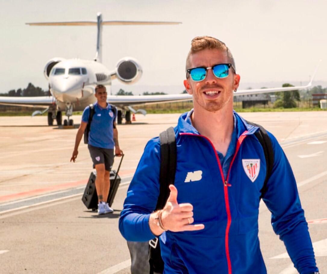 Iker Muniain saluda tras aterrizar el avión en Italia.