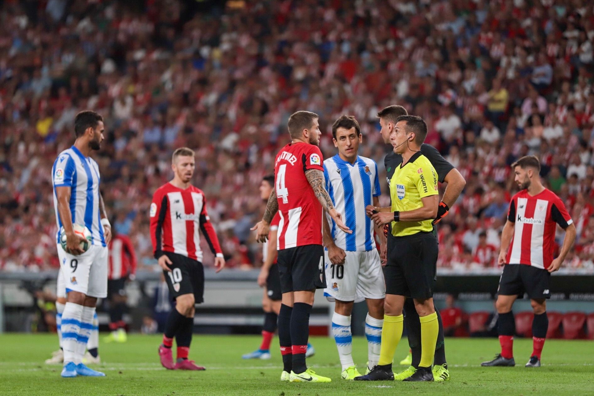 Iñigo Martínez habla con el colegiado del derbi Estrada Fernández.