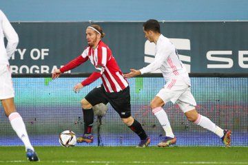  Iker Muniain intenta progresar con el esférico ante Lucas Vázquez.