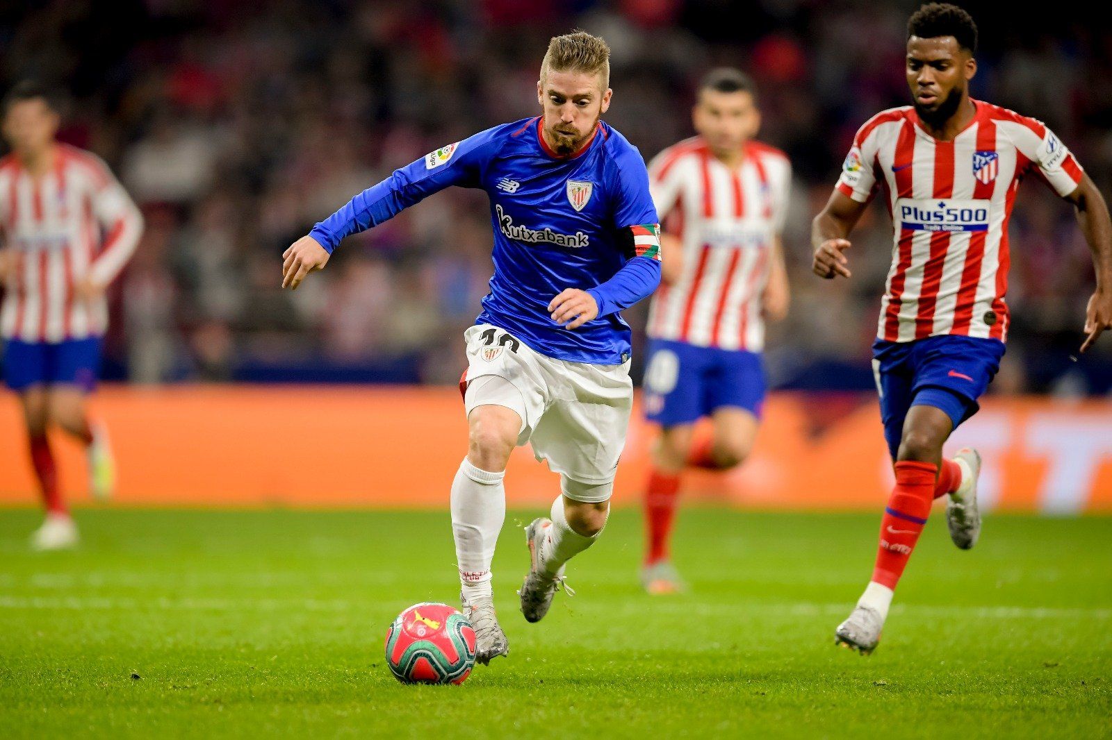 Iker Muniain conduce el balón ante la presencia de Lemar en el Wanda.