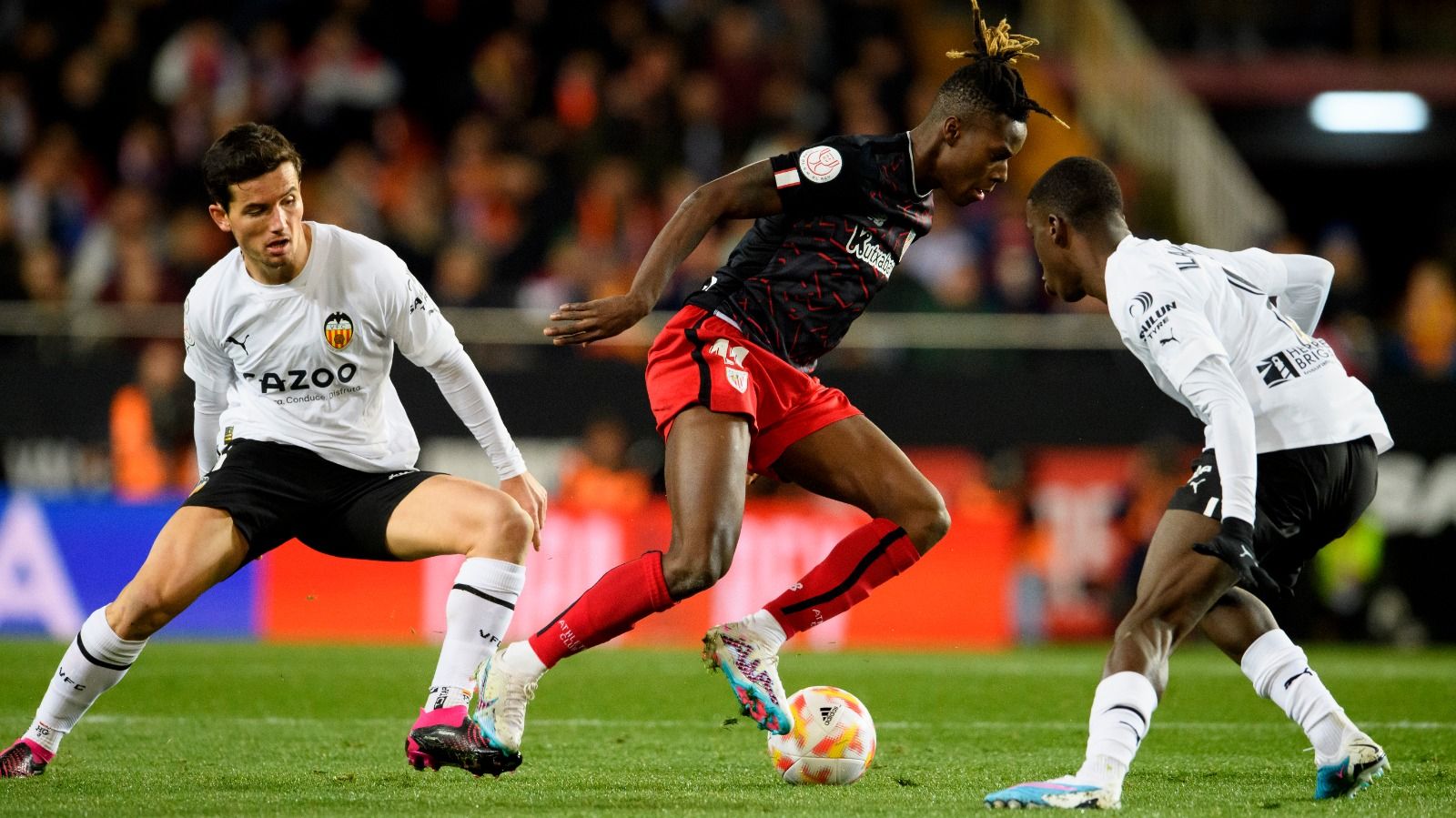 Nico Williams encimado por dos rivales en el Valencia-Athletic de Copa.