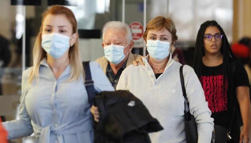 Varias personas pasean con mascarilla.